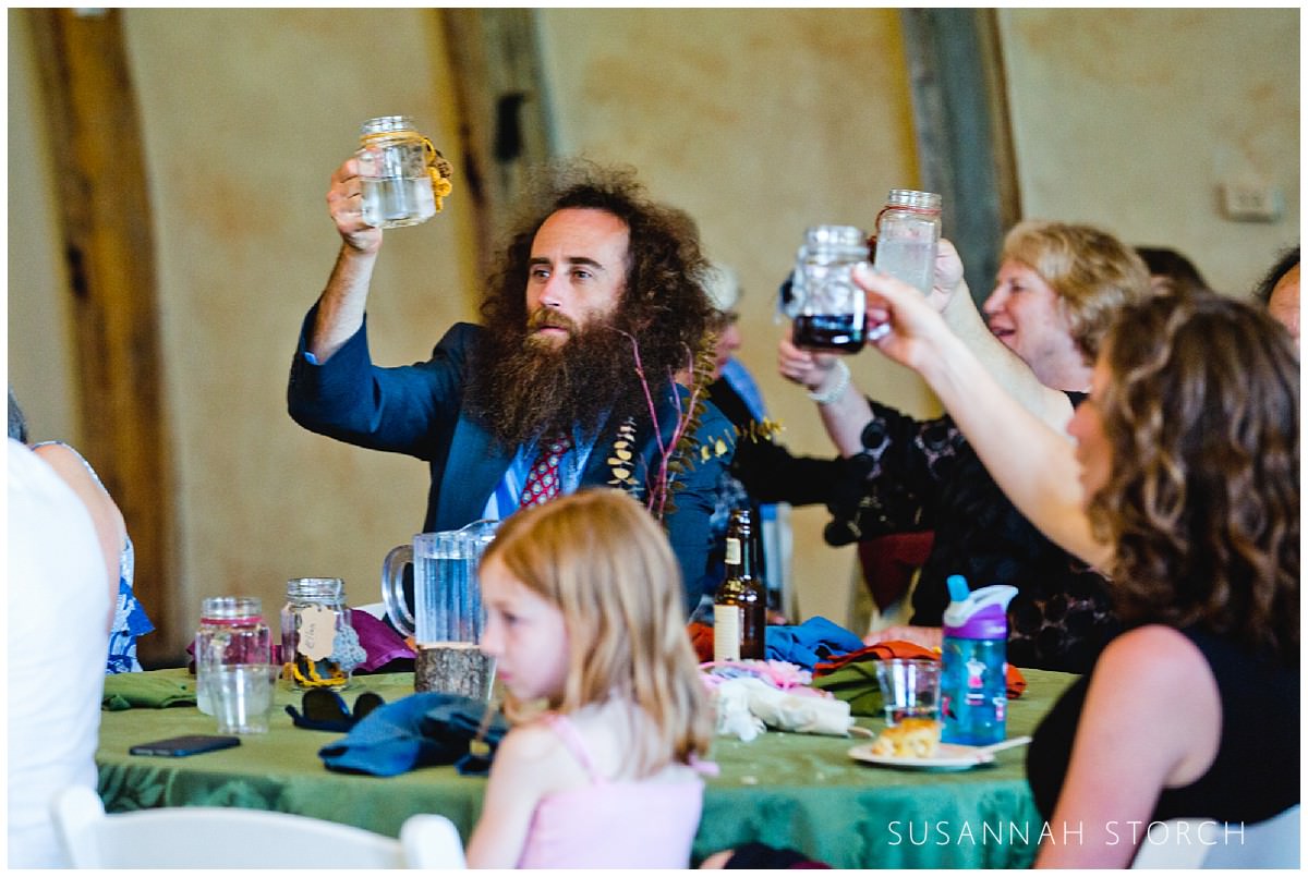 a bearded man raises his glass