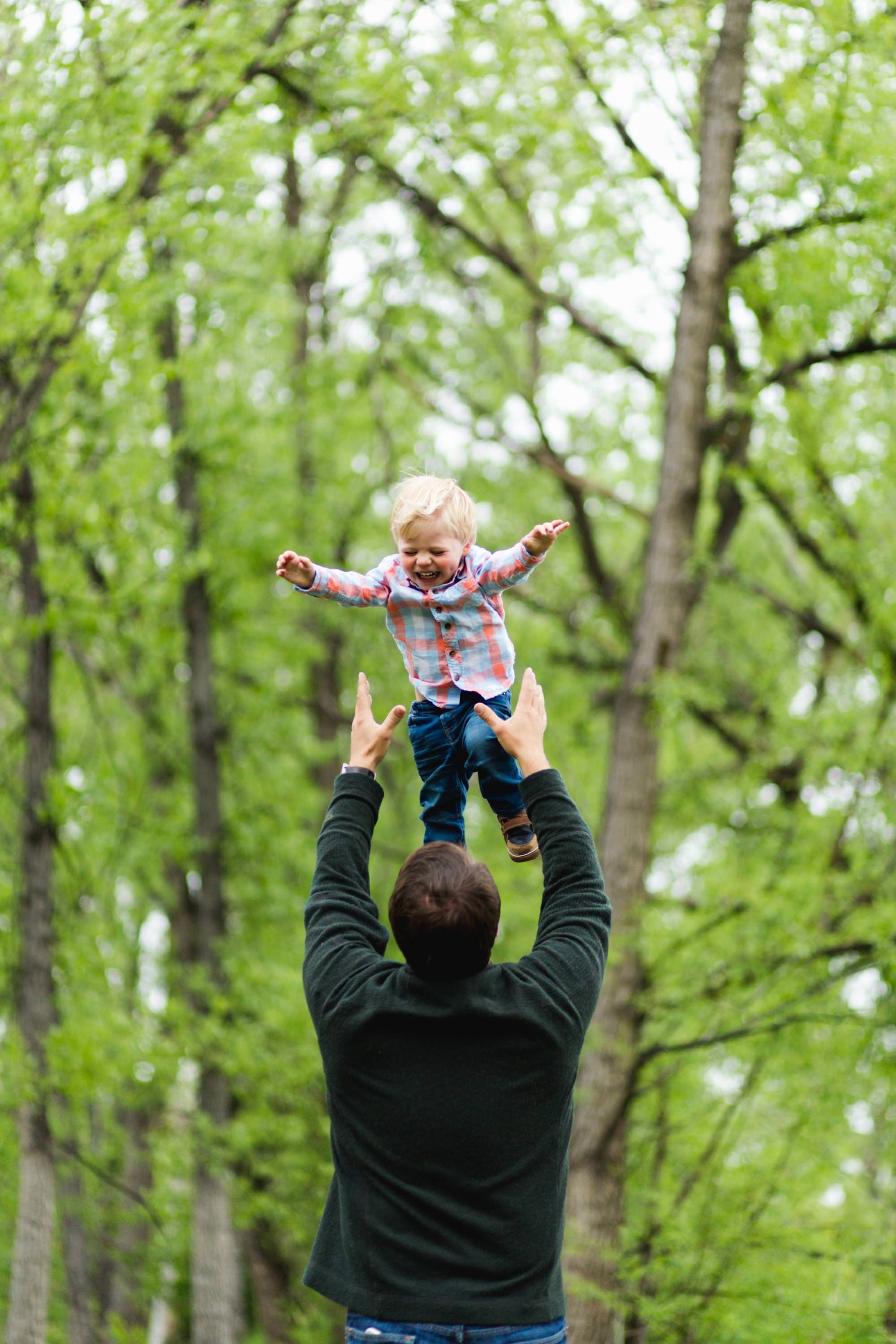 a dad throws his son in his air
