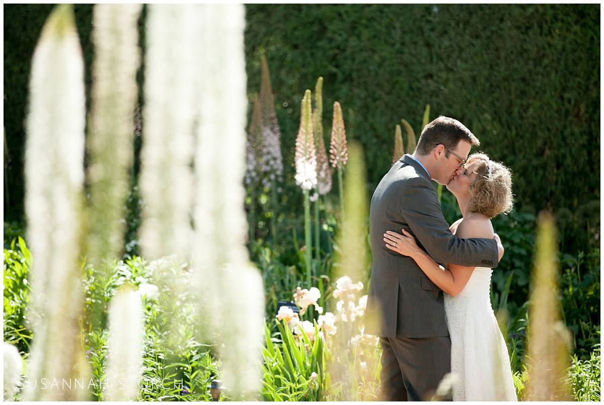 a wedding couple kiss among flowers