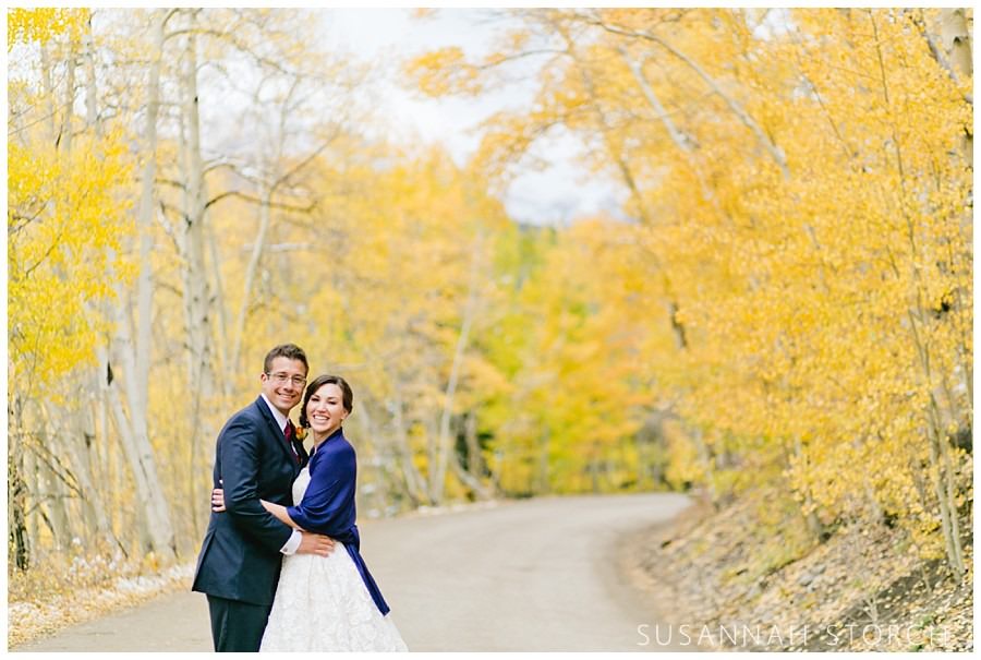 wedding couple pose among yellow aspen trees