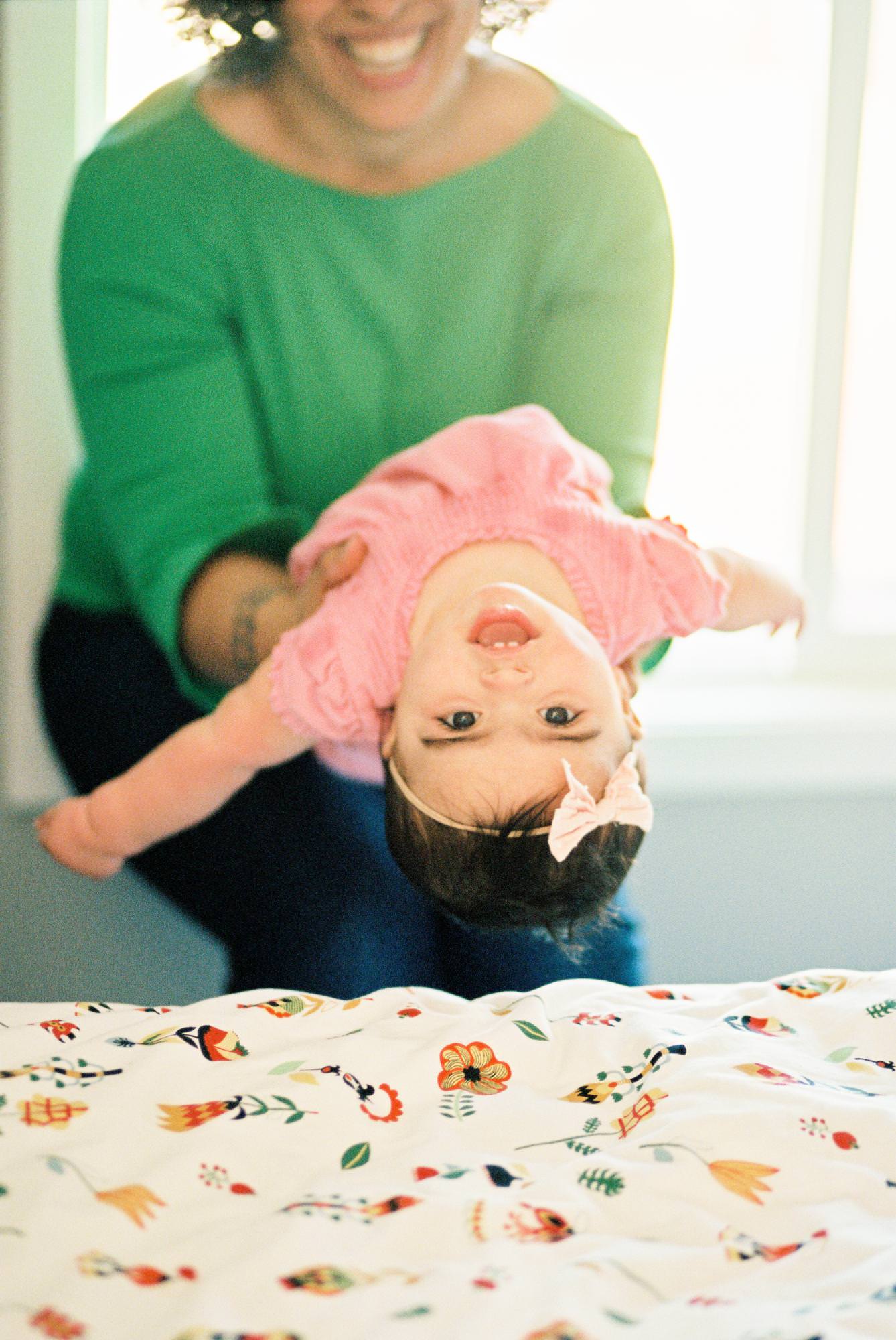 A mom holds her baby upsidedown