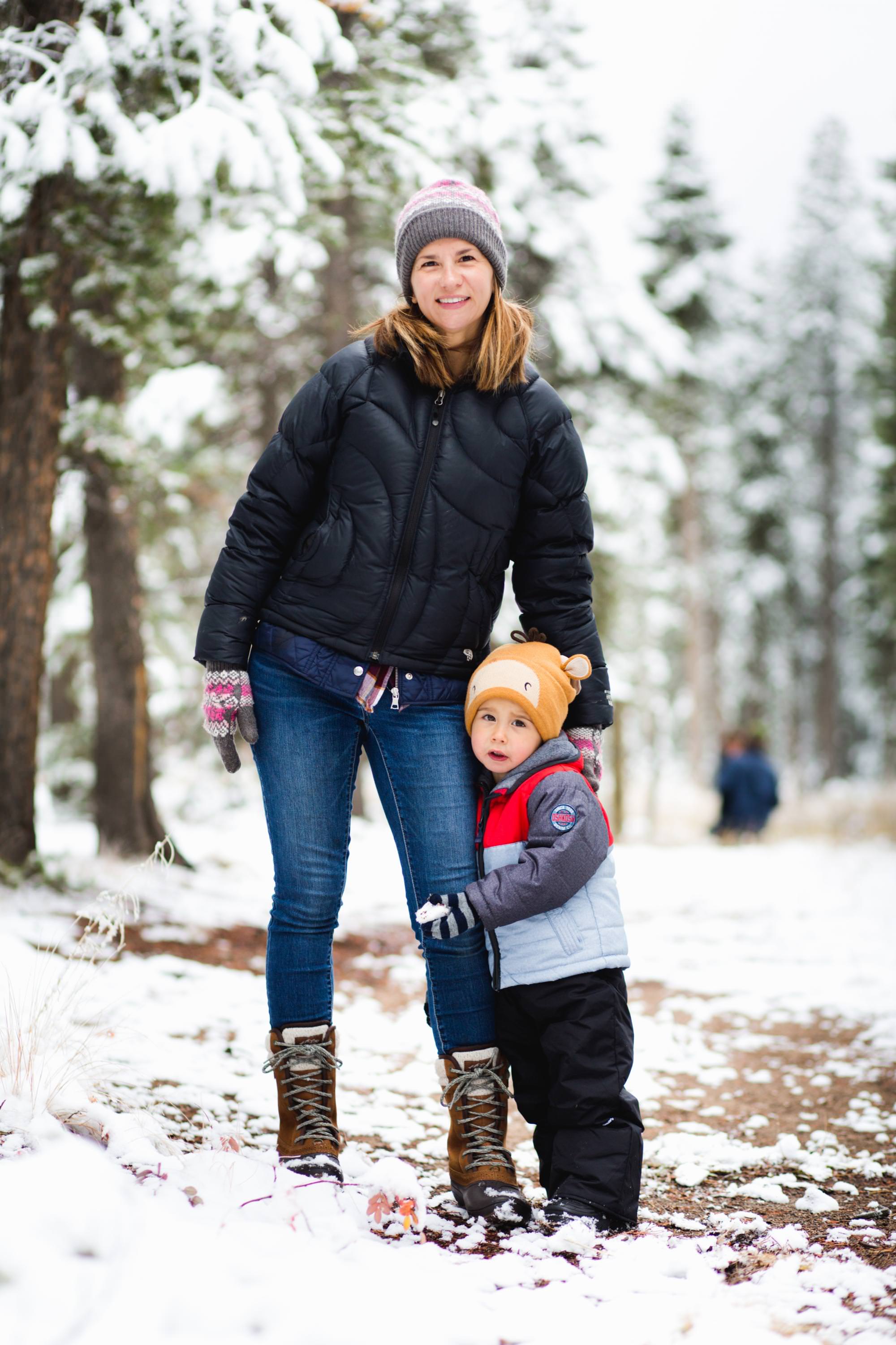 mom and son look at camera on snowy day