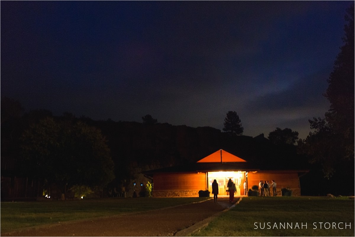 silhouettes in front of a lit yurt at night