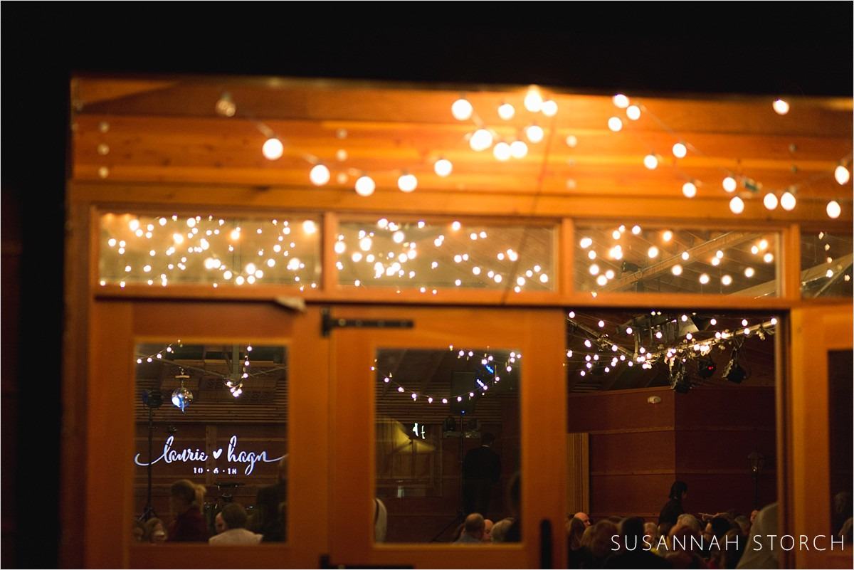 fairy lights sparkle in front of a brown wooden building