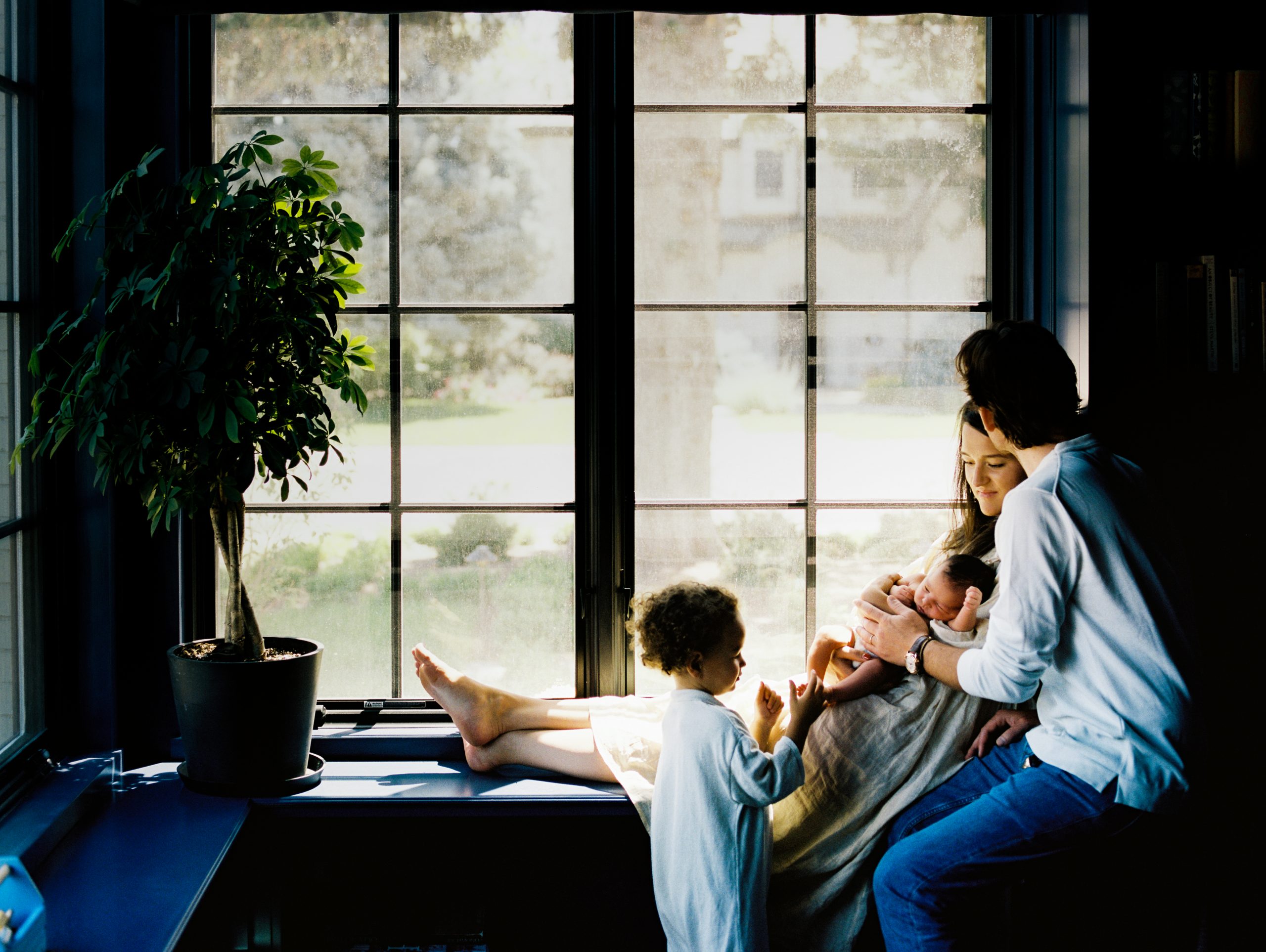 colorado family sits in window sill during newborn portrait session
