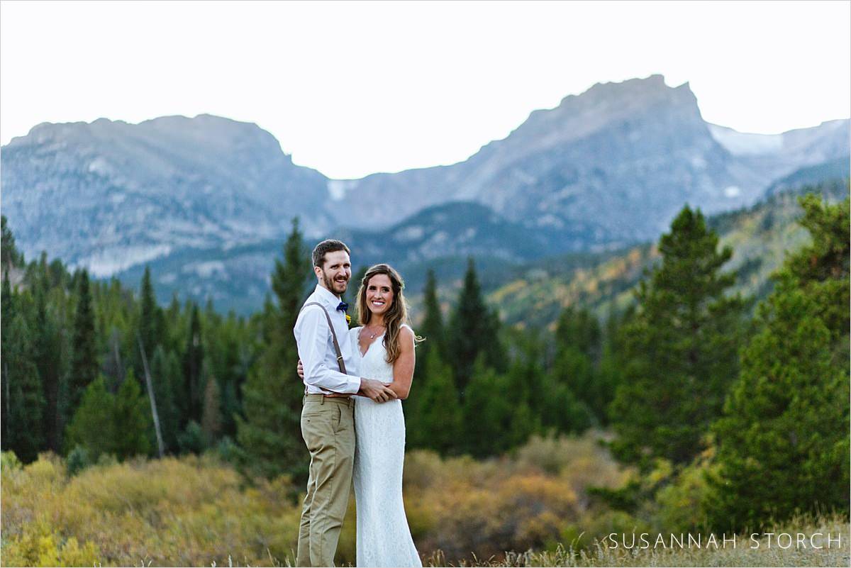wedding couple stand in front of mountain in Rocky Mountain National Park
