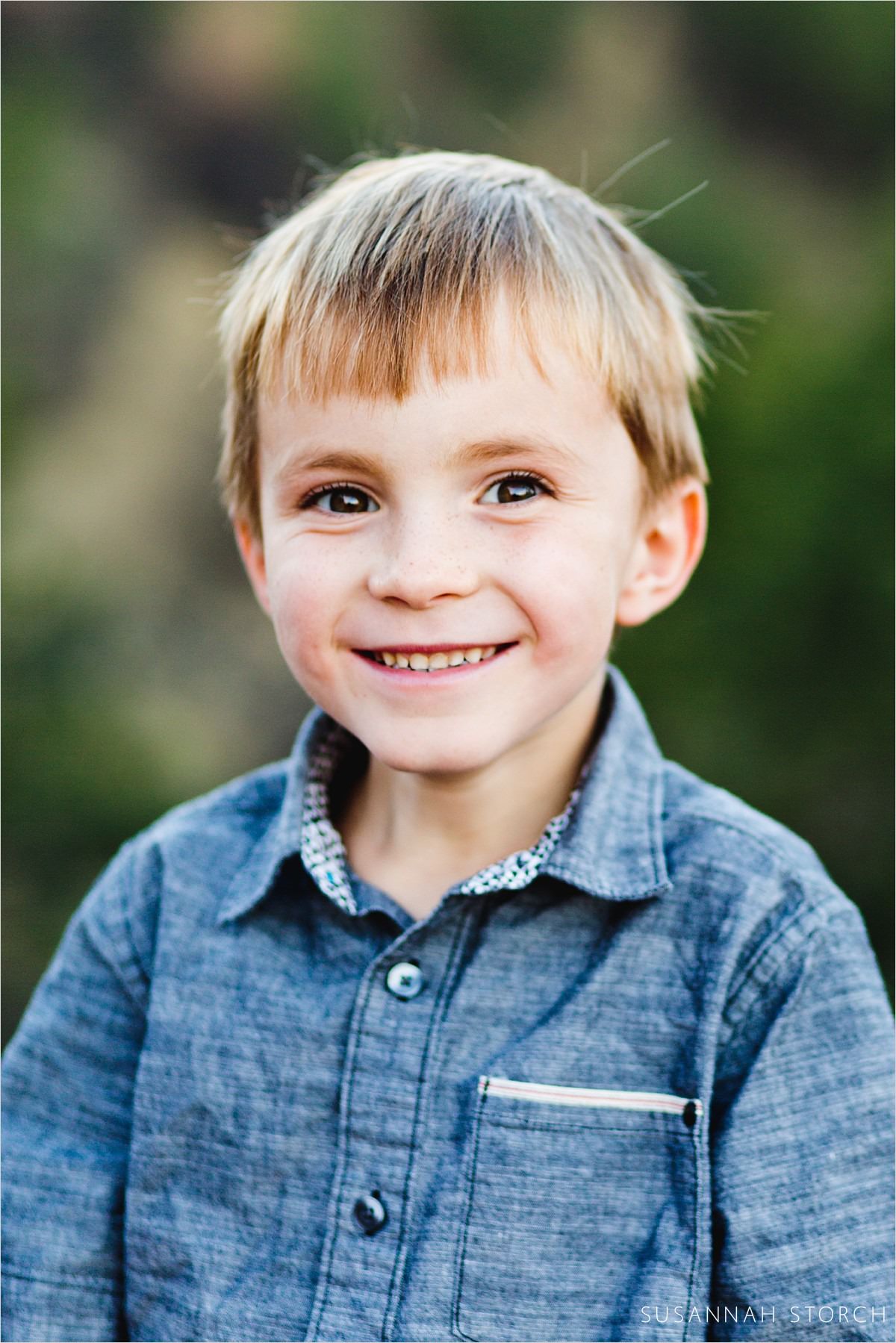 portrait of a cute boy in a blue shirt smiles