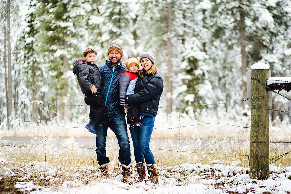 family stands under snowy trees in colorado