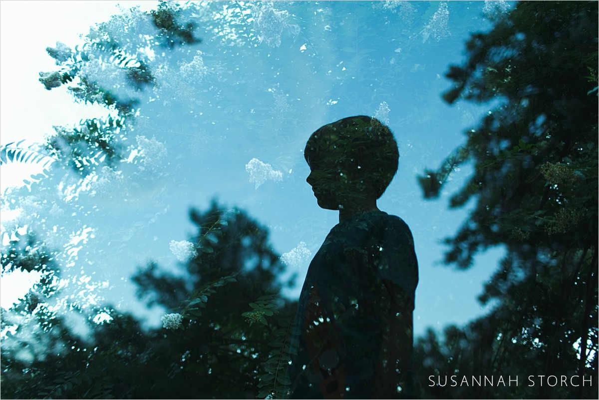 double exposure of a boy in front of trees