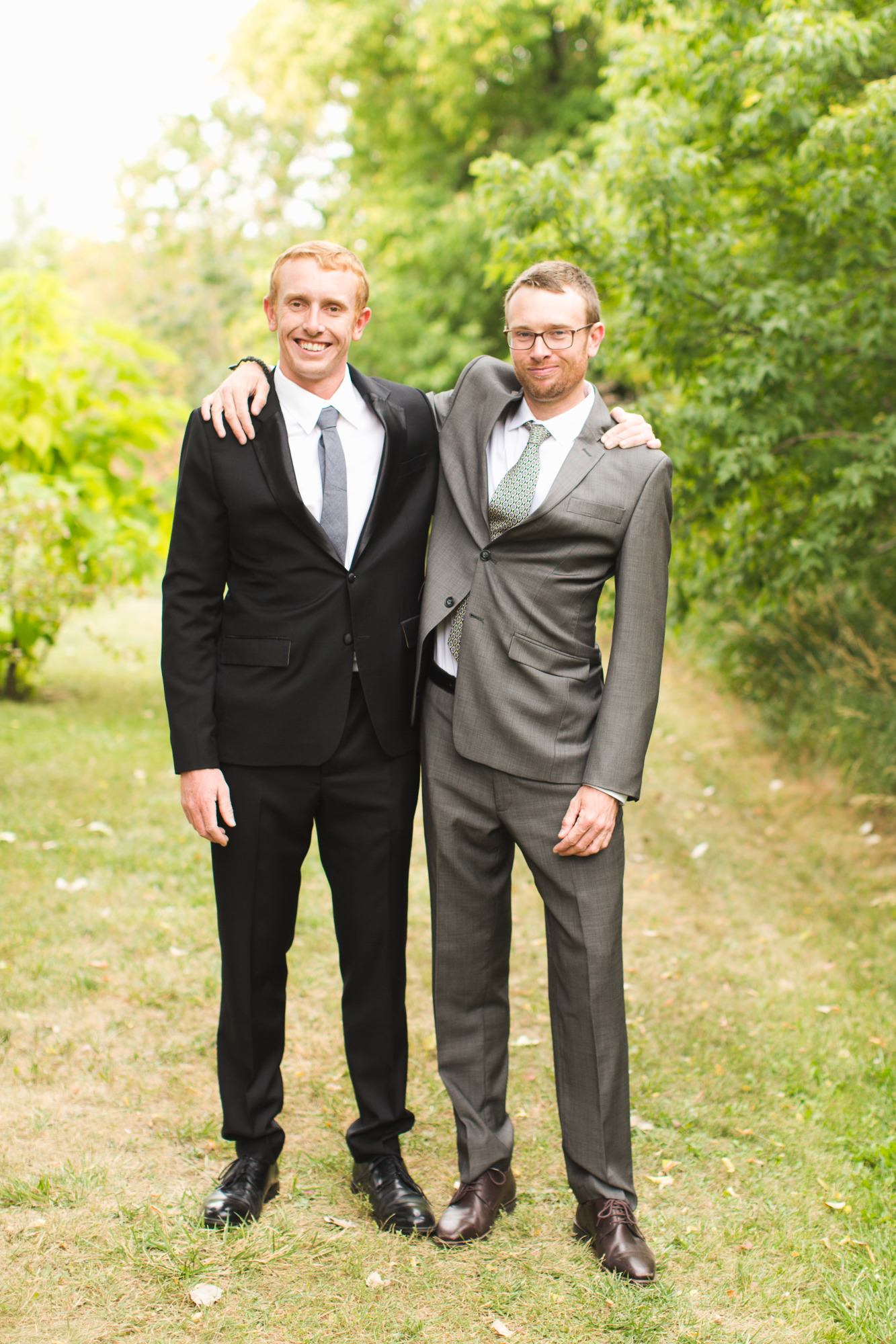 groom and brother pose for formal wedding family photos