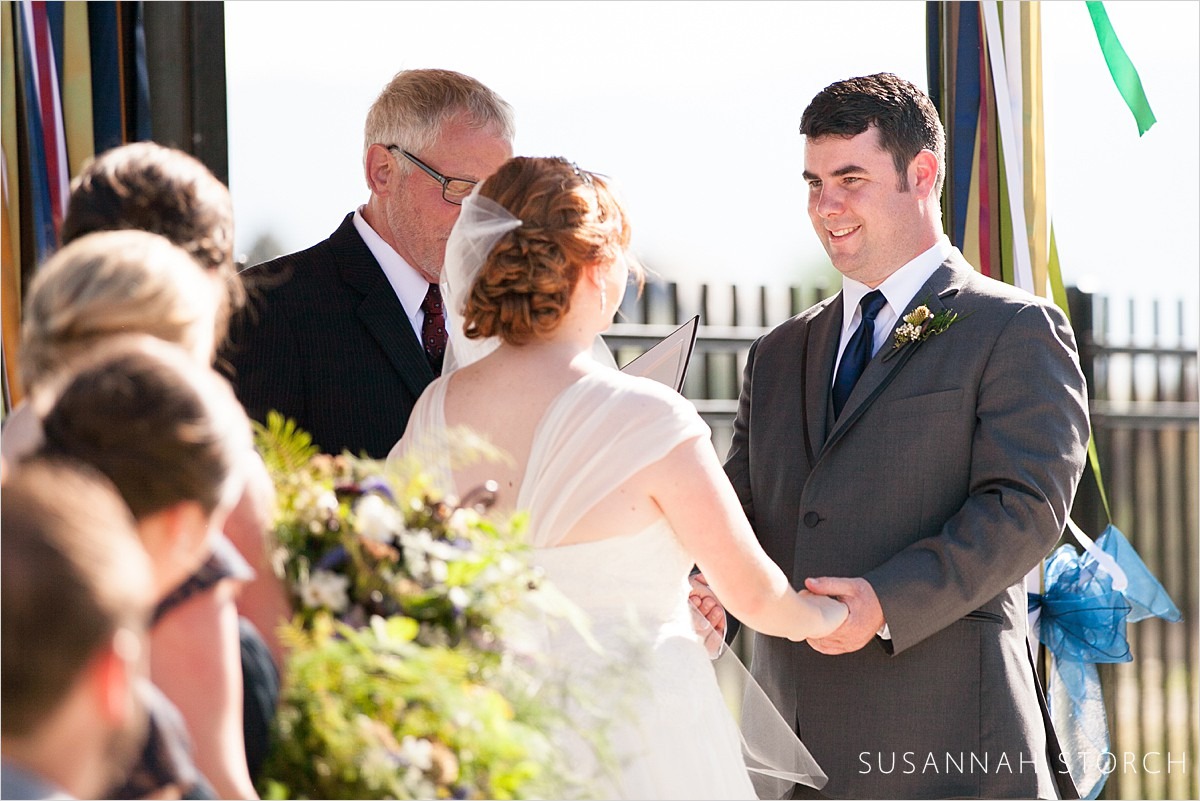 a groom gazes at his bride during his wedding ceremony