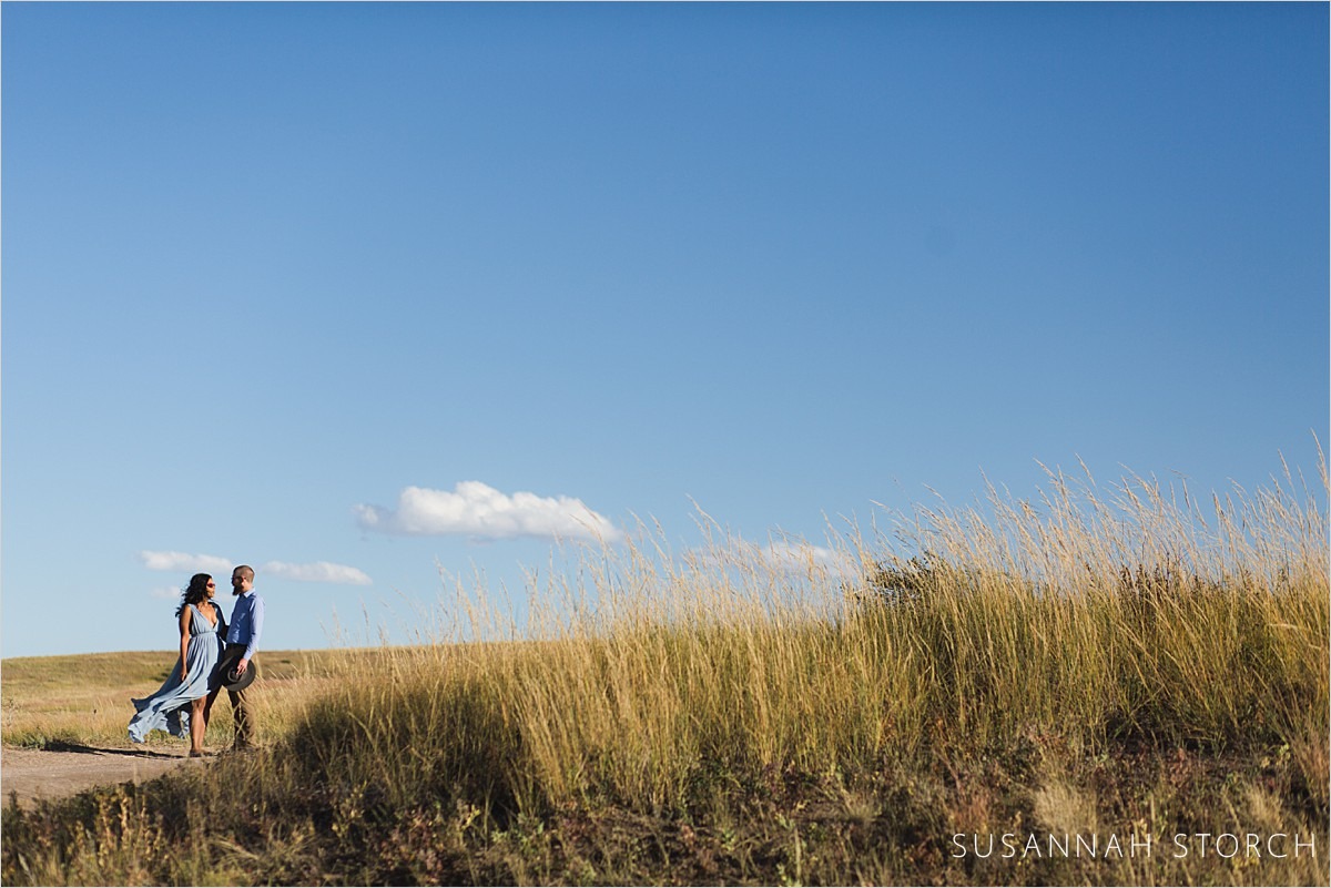 blue skies, tall grasses, and a couple in love
