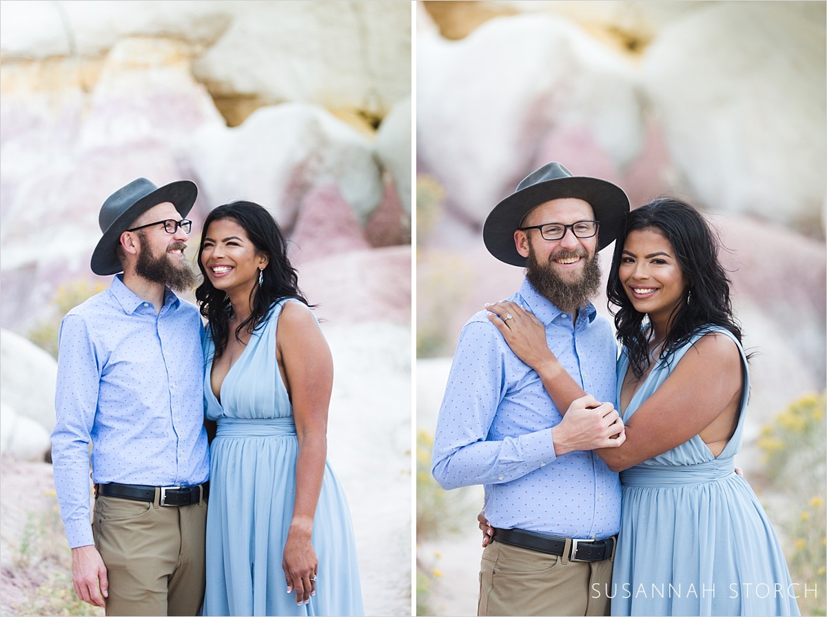 laughing engaged couple stand in front of rocks
