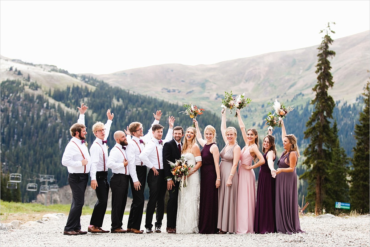 bridal party stands in front of colorado mountains