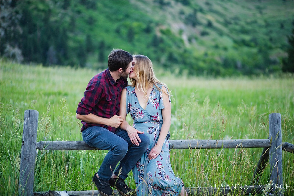 a couple kiss in front of a mountain