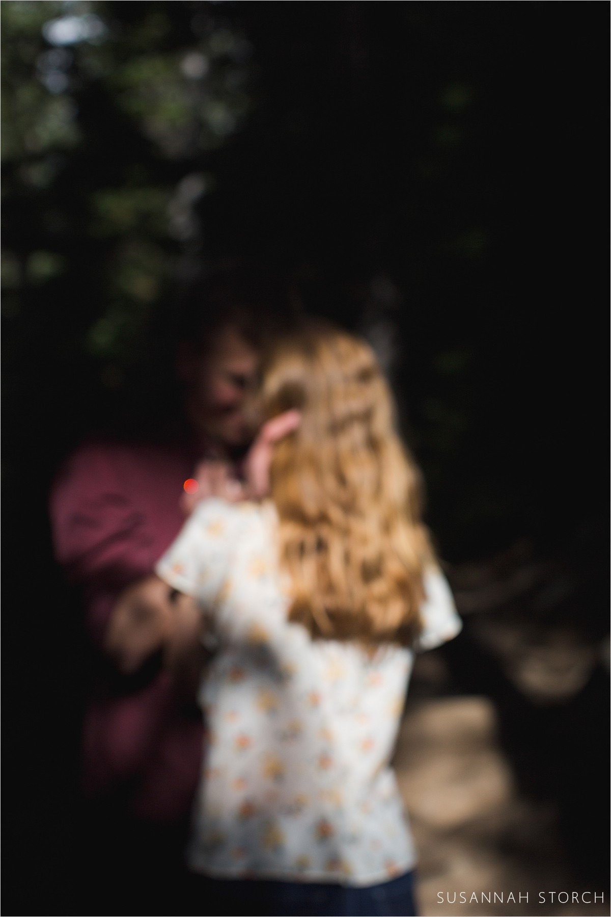 blurry photo of a couple looking at each other under trees