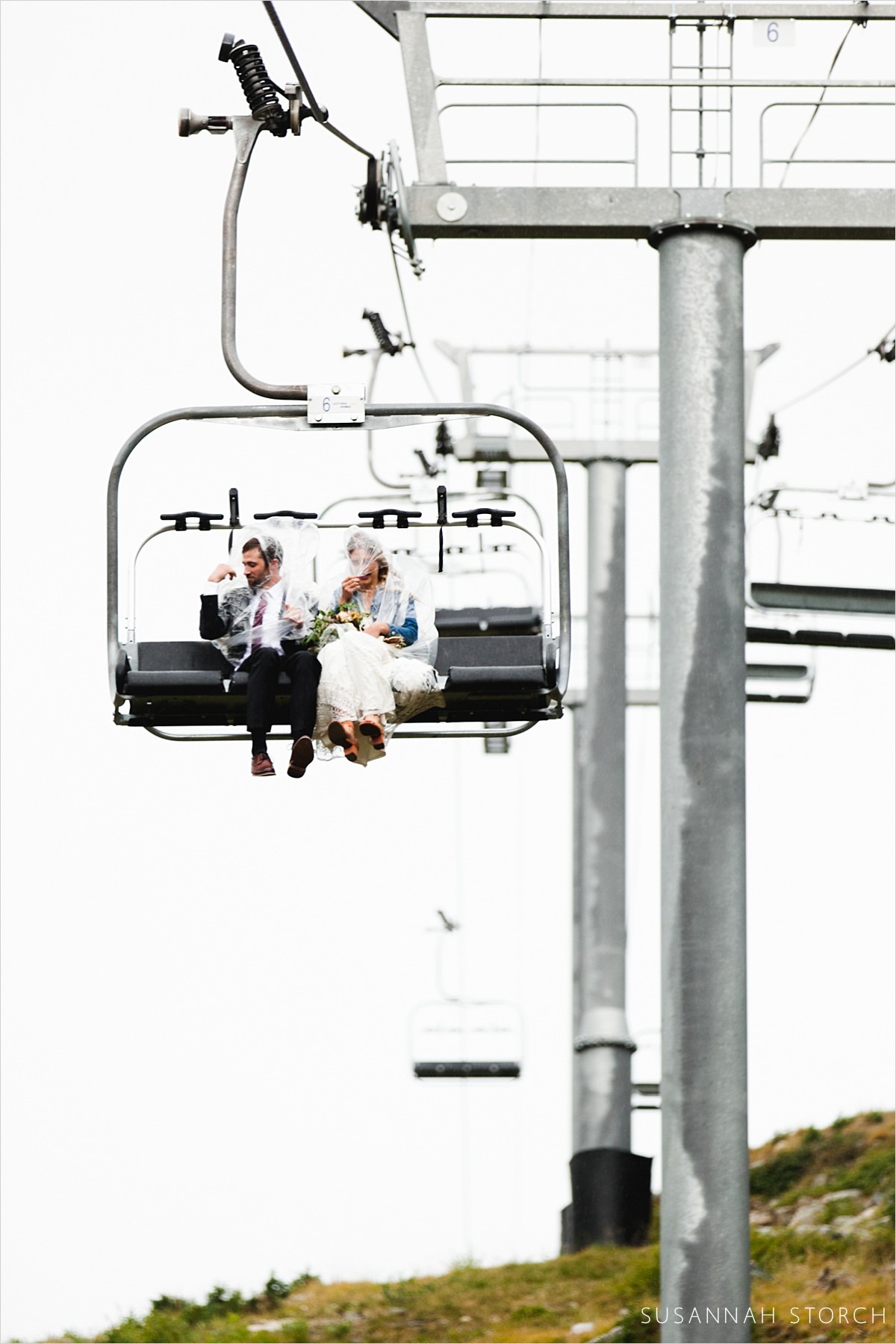 bride and groom hunkered down on chairlift