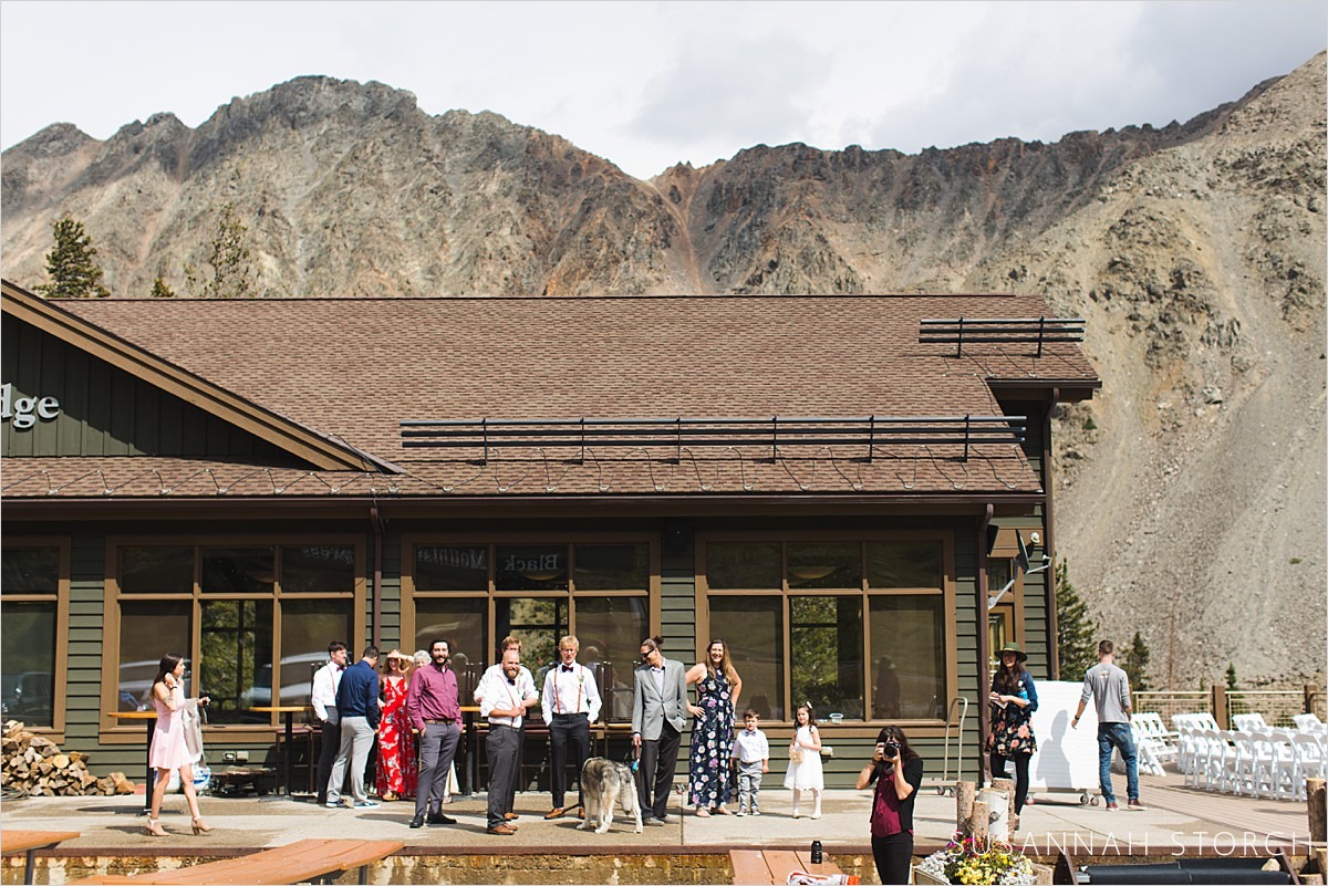guests stand in front of a building by mountains