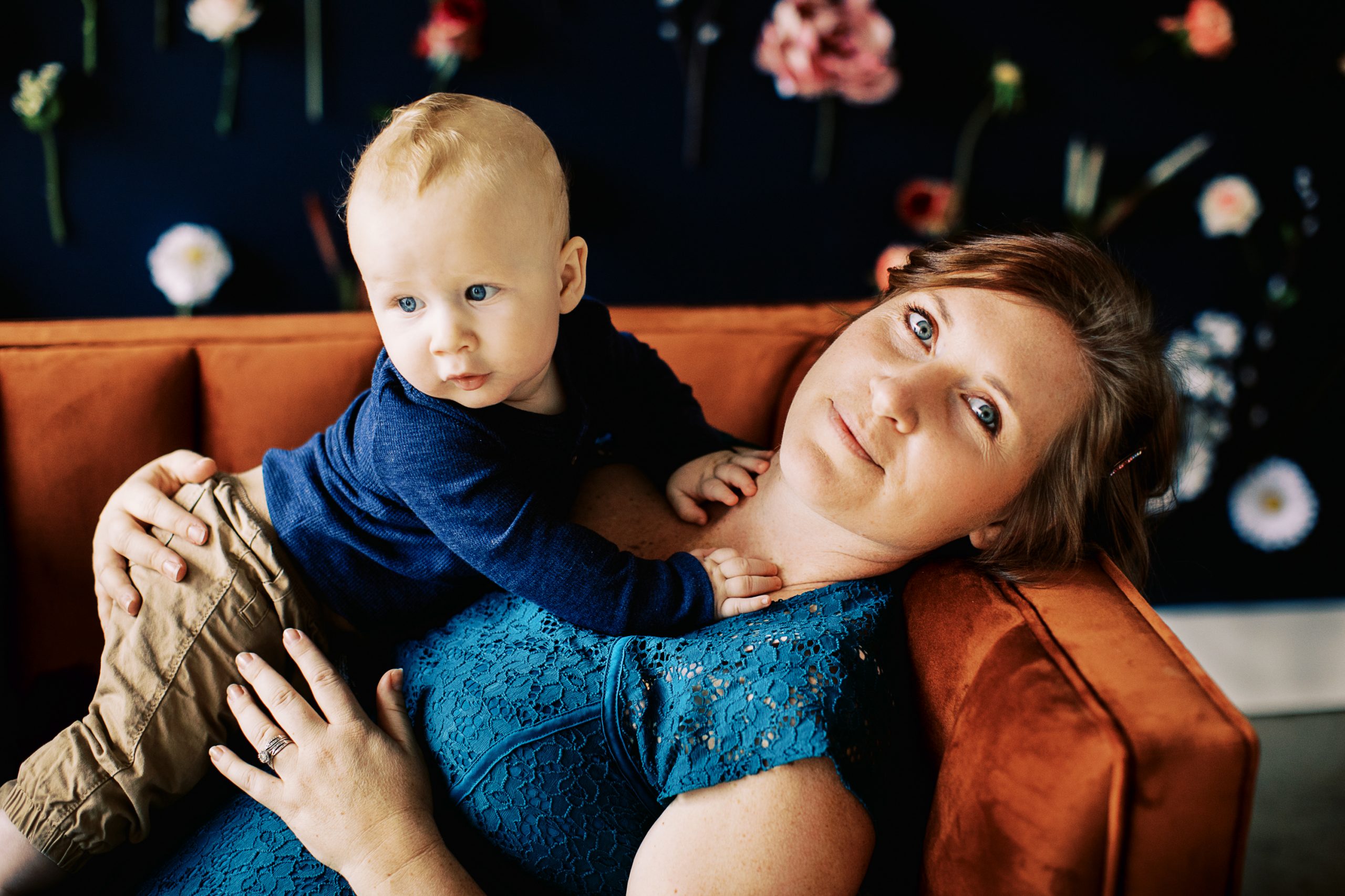 beautiful mom and baby boy snuggle on couch photo