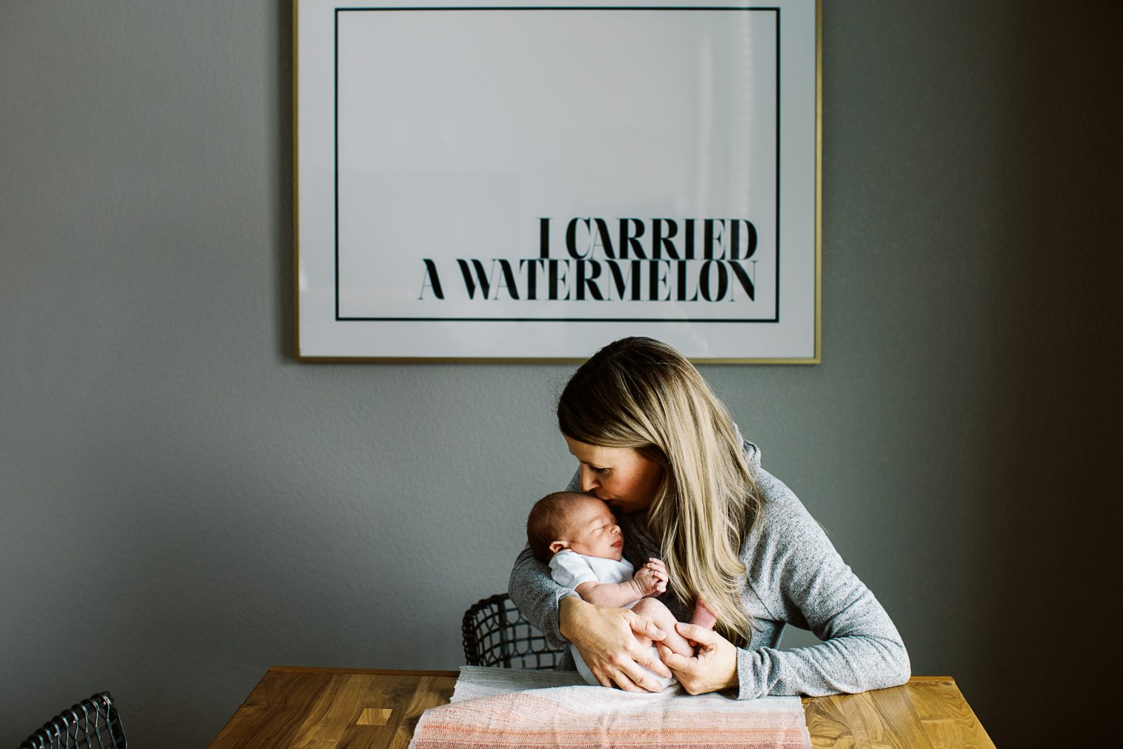 mom kisses newborn baby son's head