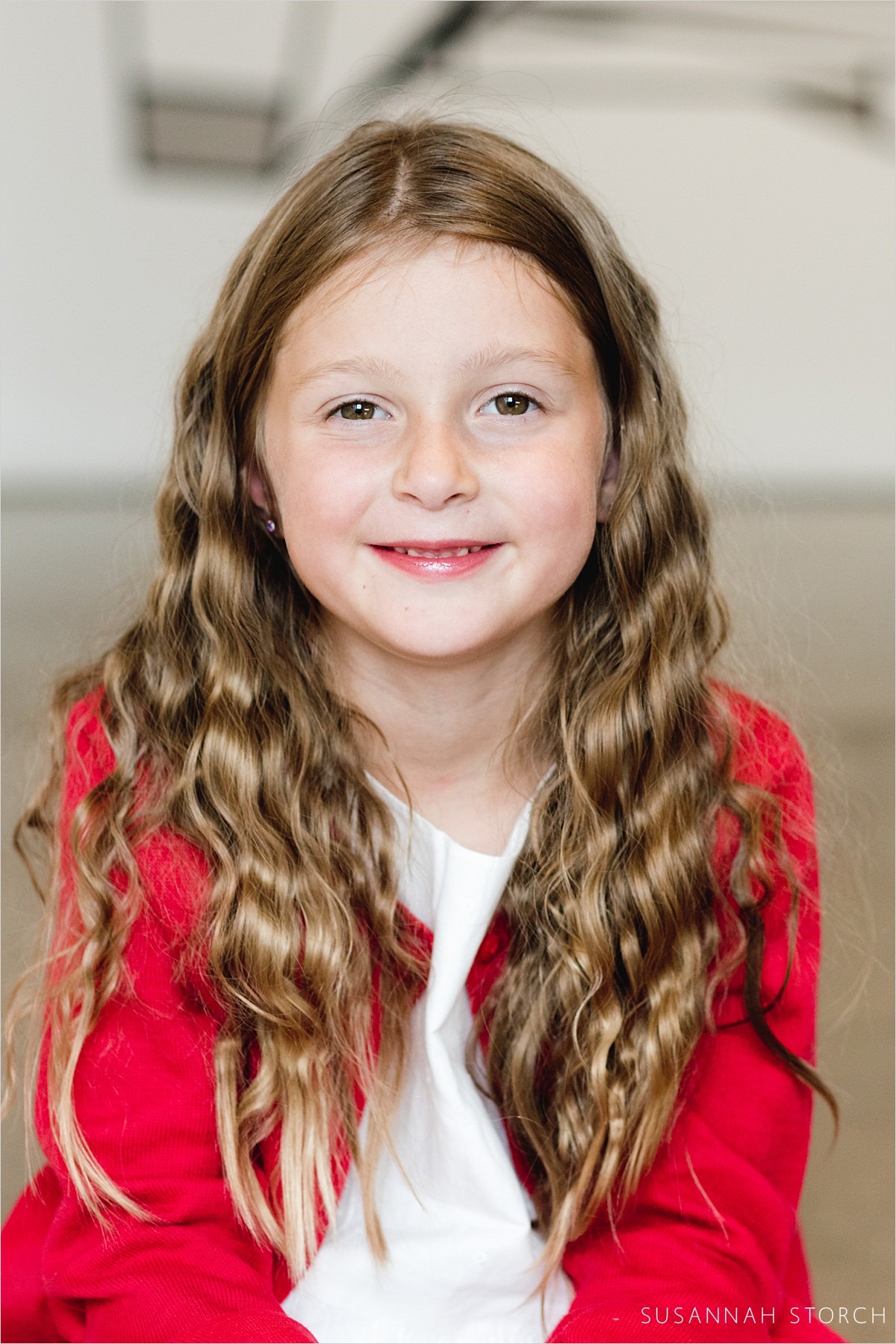 portrait of young girl with wavy hair and a red sweater