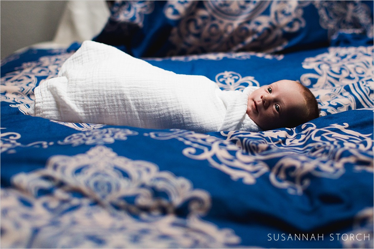 newborn baby boy on blue comforter