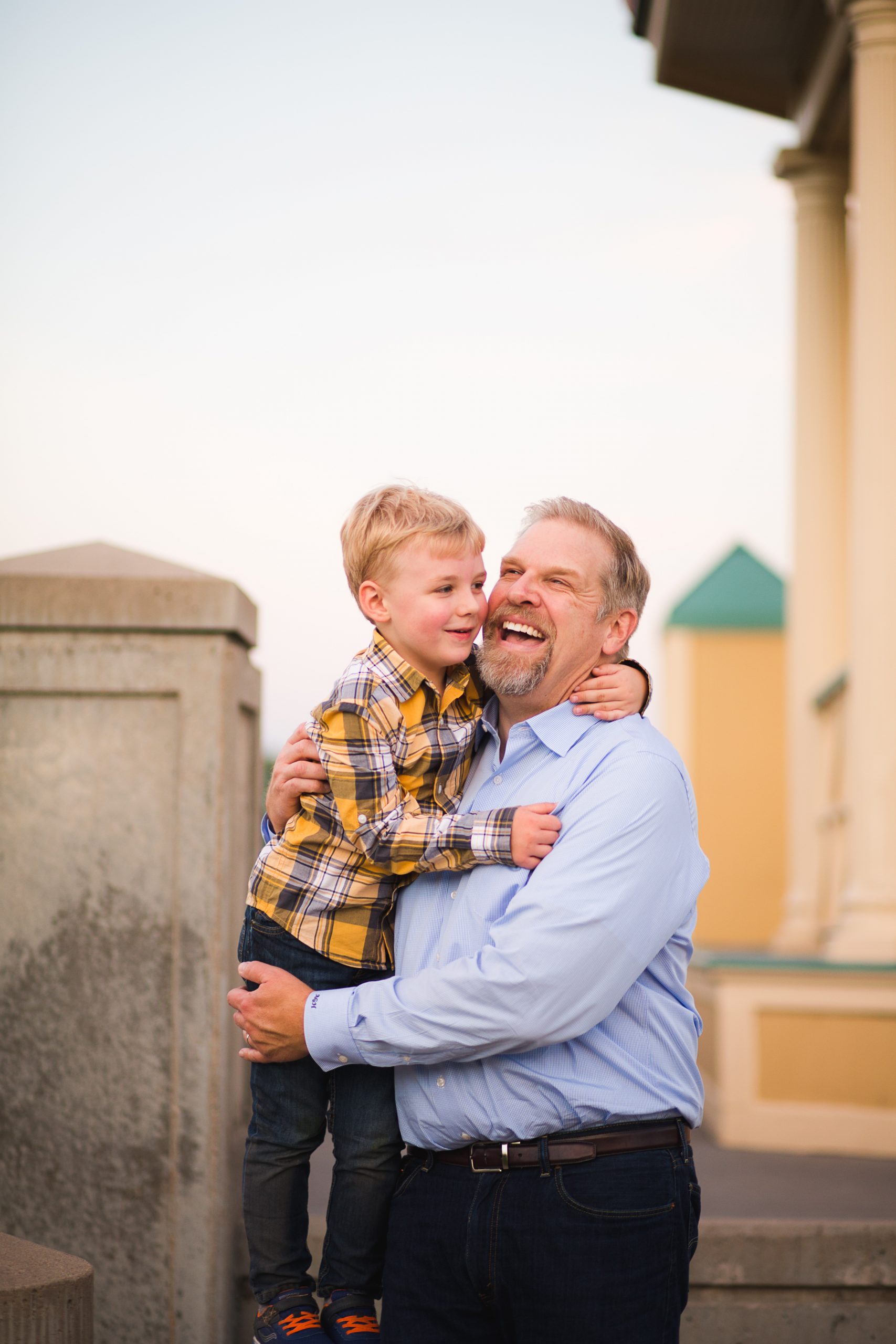 a dad holds his son and laughs during a photo session