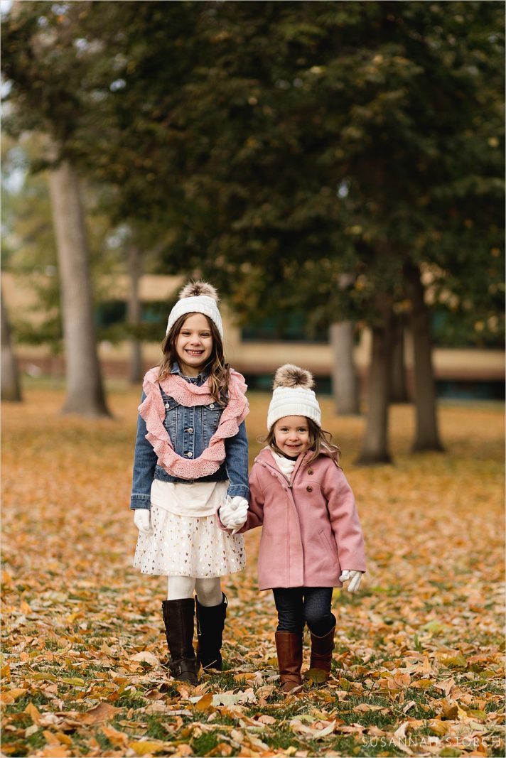 sisters hold hands and pose for camera