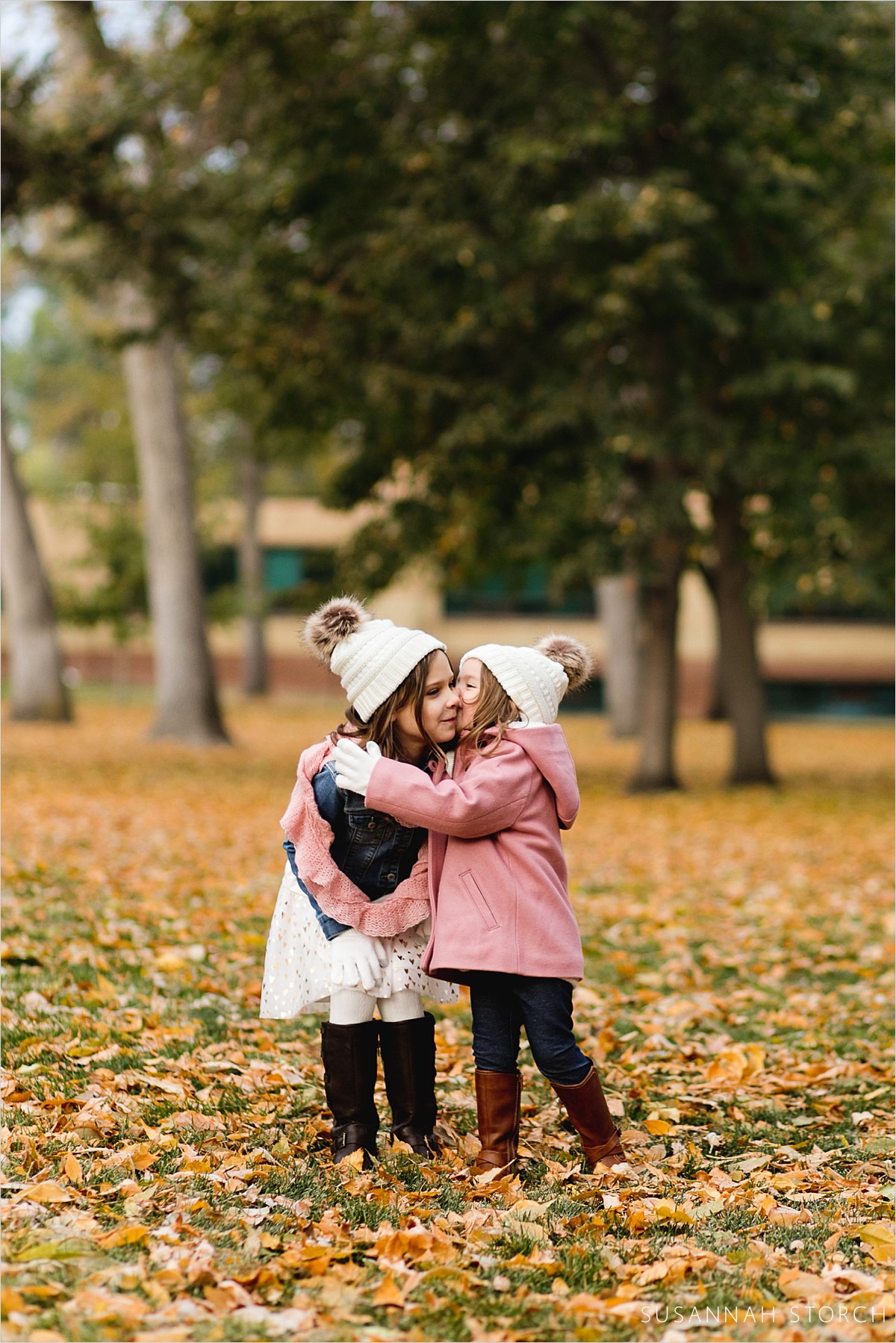 sisters hug and kiss during a fall family photo session
