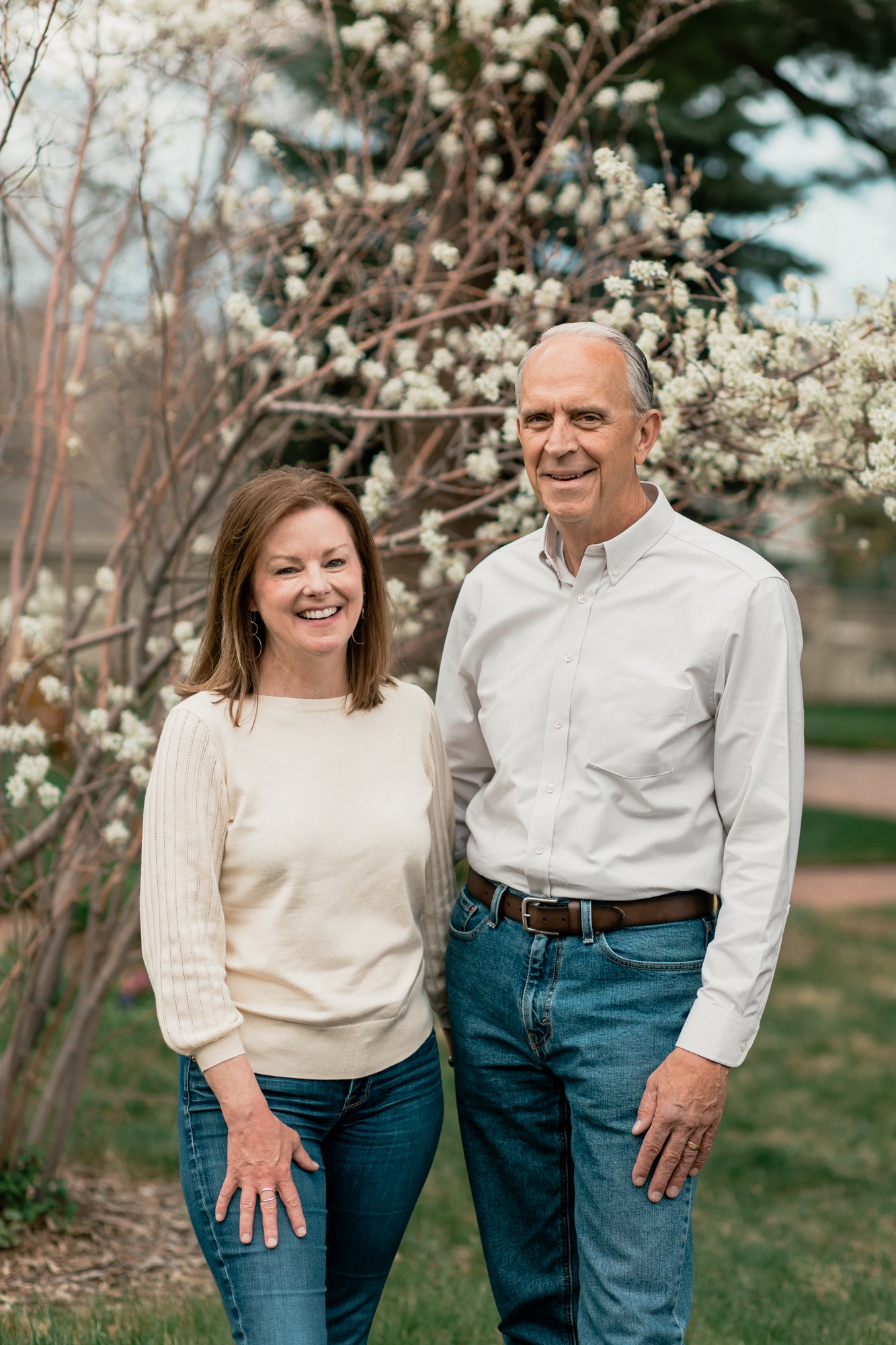 photo of grandparents standing in front of flowering tree