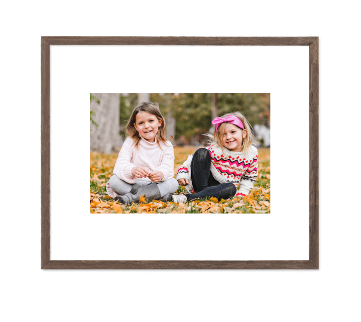 framed photos of sisters sitting in leaves by susannah storch photography