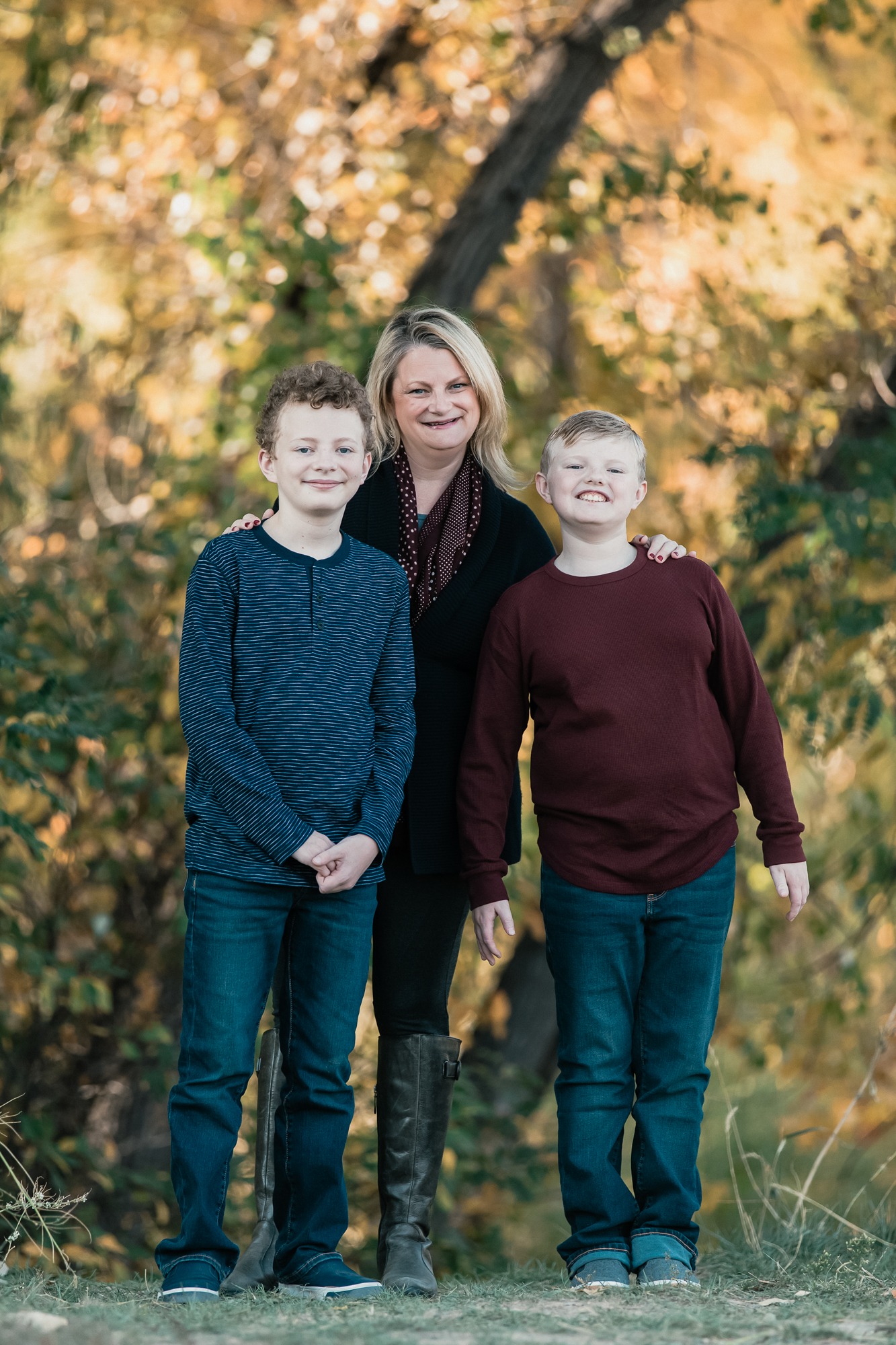 portrait of mom and sons in front of fall trees