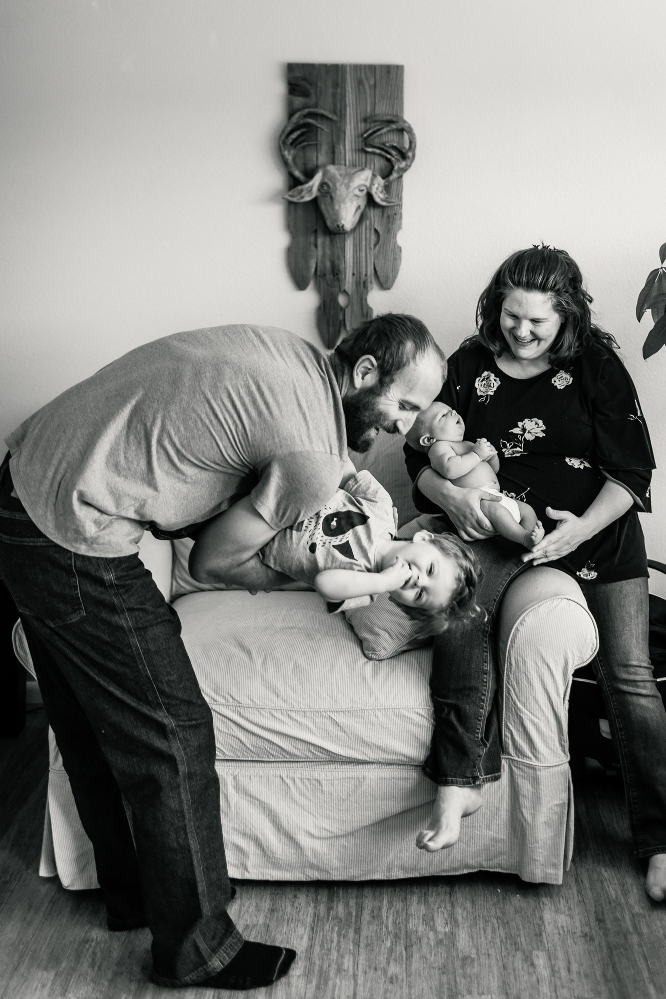 black and white photo of a family with newborn and older sibling