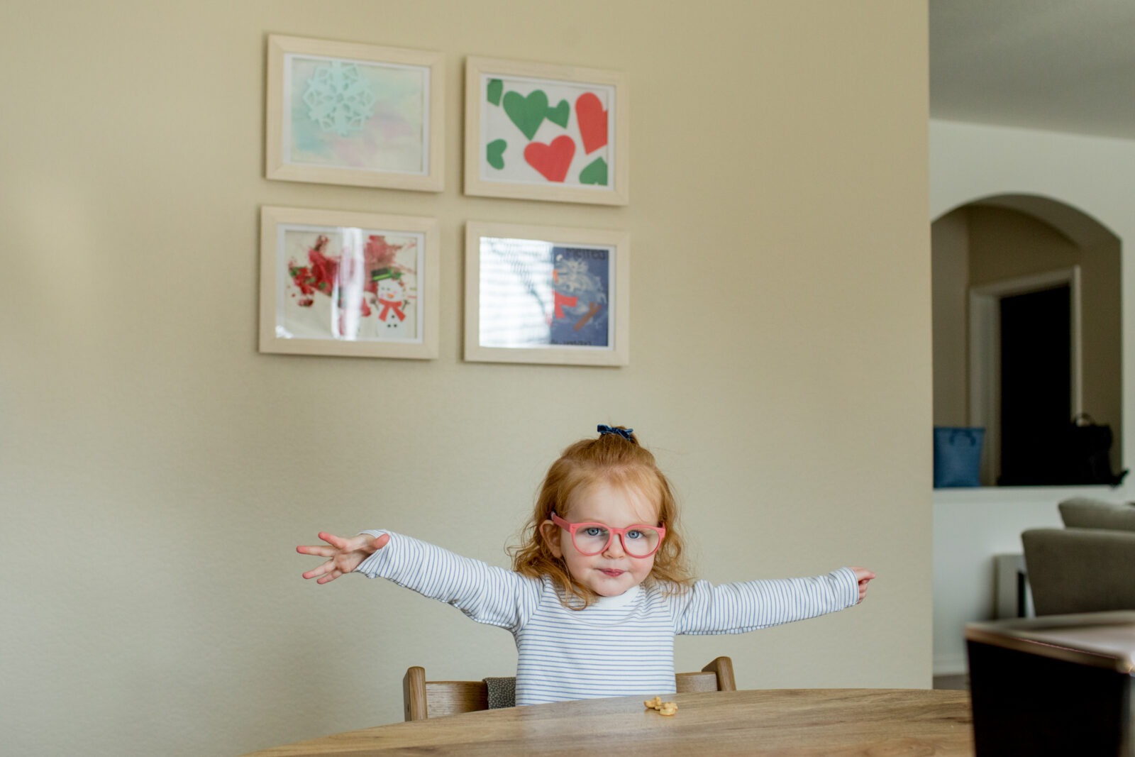 young girls stretches out her arms during an in home photo session
