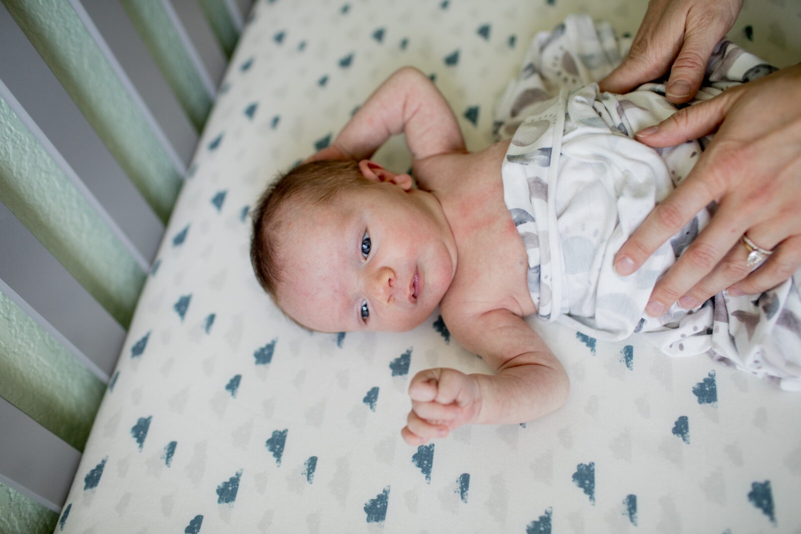 newborn baby lies in his crib