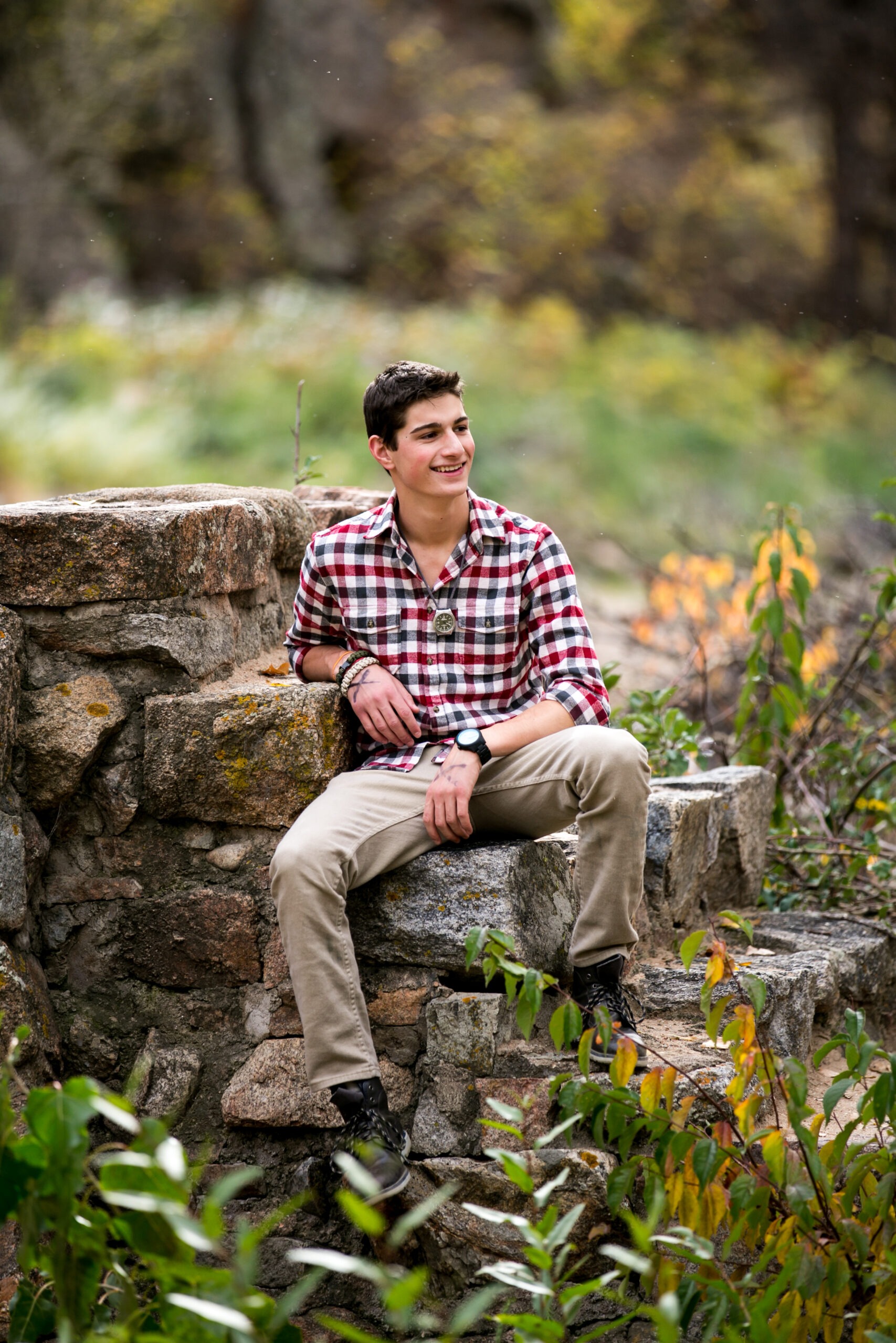 Skyline High School senior boy poses on rock steps during his senior photo session
