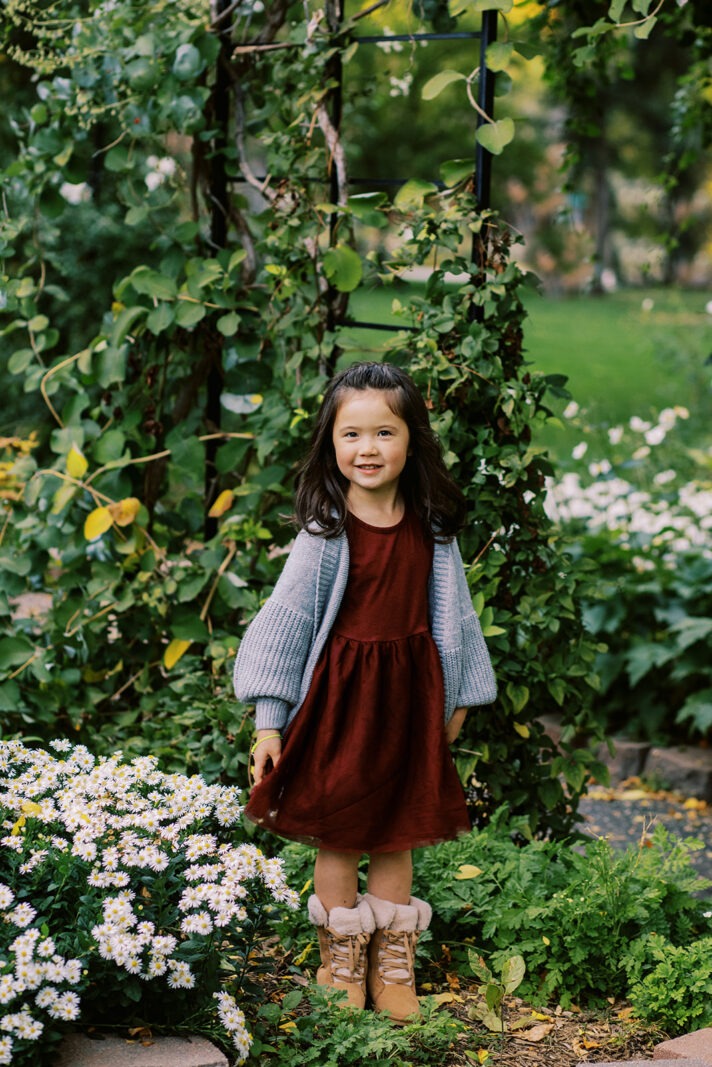 Longmont fall family portrait of daughter standing in front of green plants