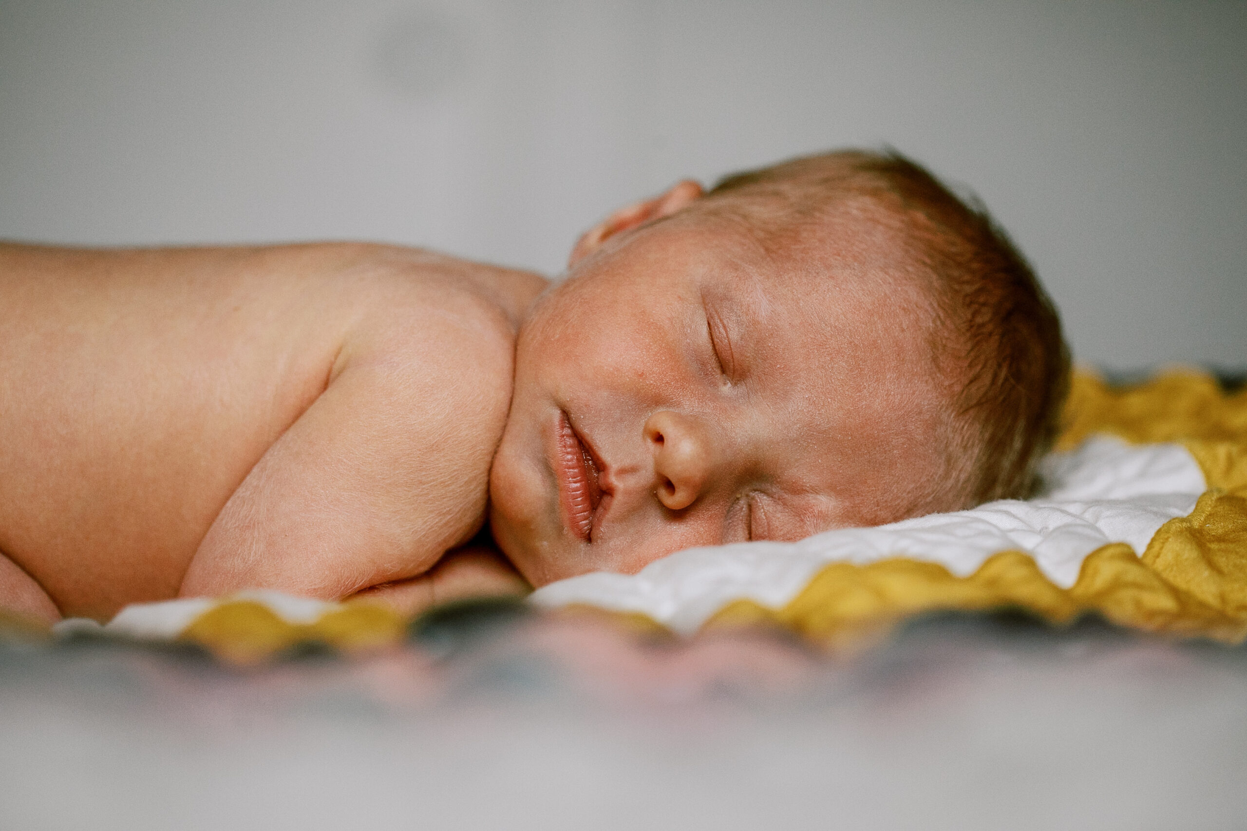 Luxury newborn photographer Berthoud CO — baby sleeping on blanket during in-home session.