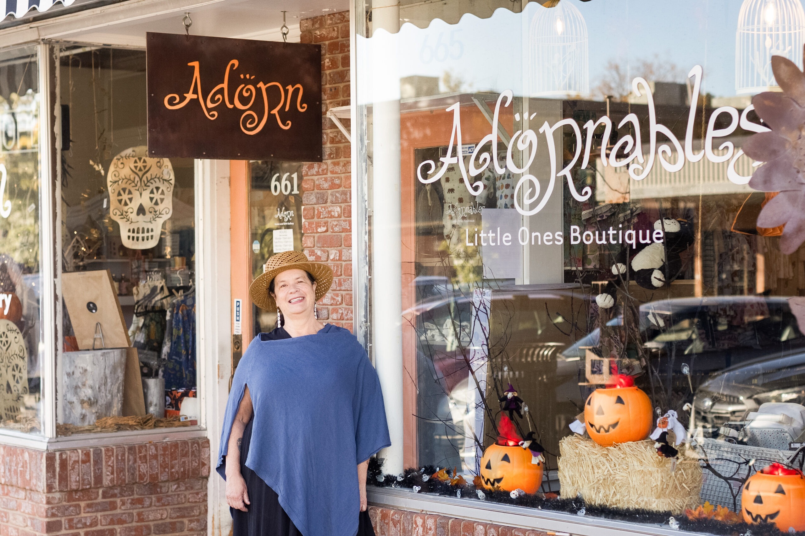 Sharald, owner of Adornables boutique in Old Town Longmont, Colorado, stands outside her woman-owned children’s shop known for sustainable toys, organic baby clothes, and curated gifts.