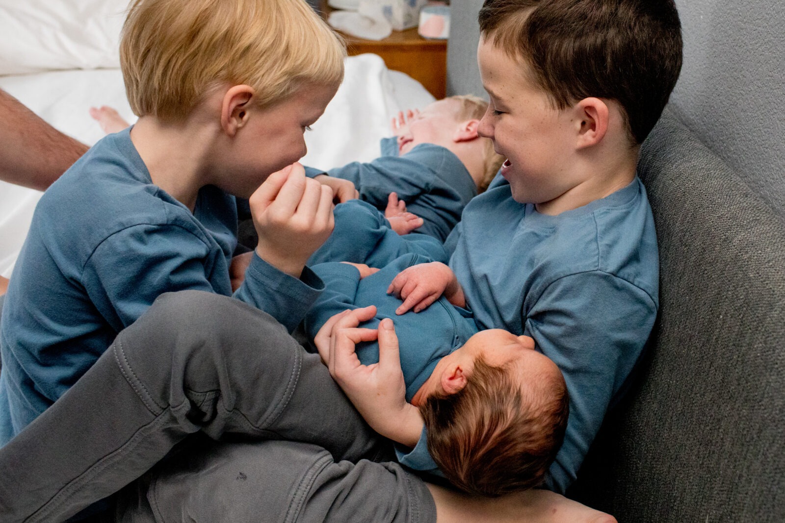 brothers hold newborn baby boy
