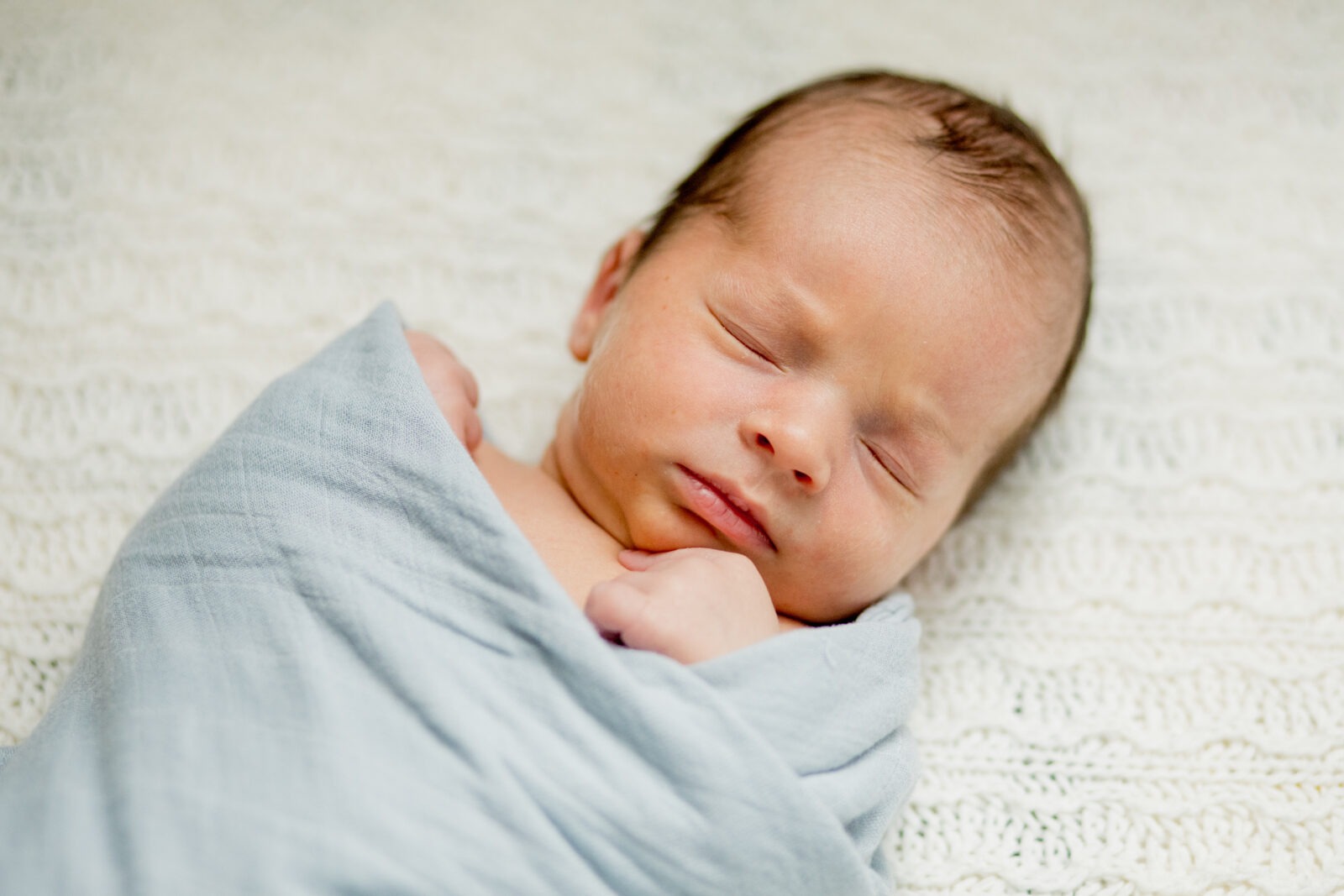 swaddled sleeping newborn during an in-home newborn photography session