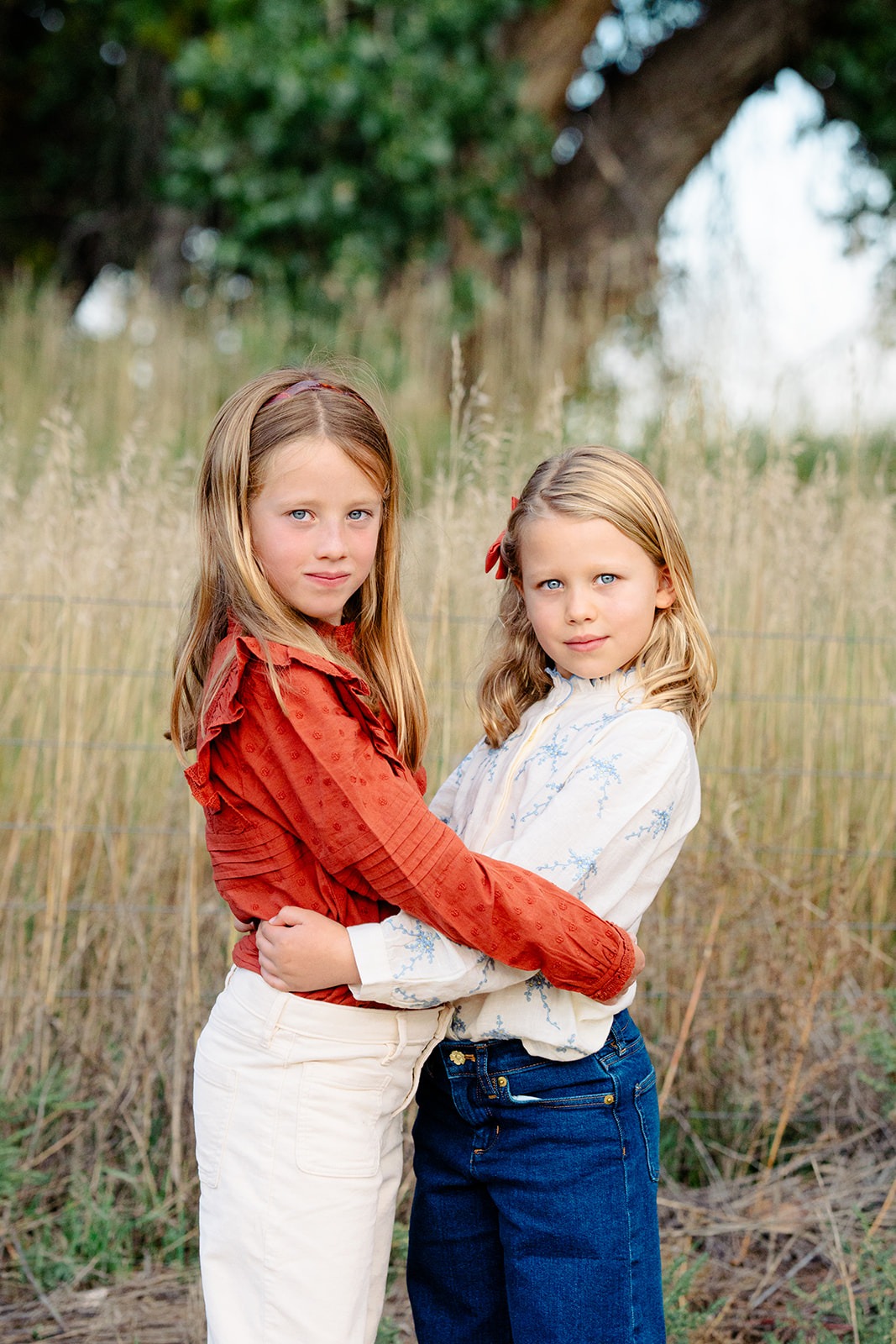 two sisters with arms around each other during spring mini session in Longmont Colorado