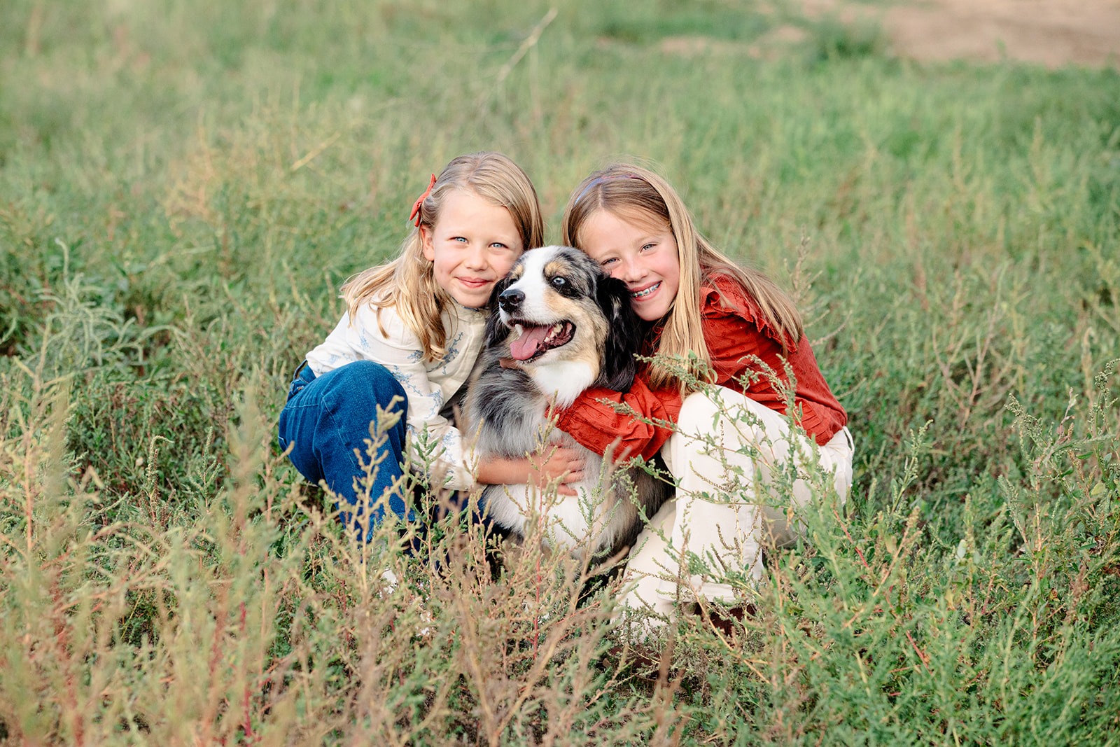 sisters hug their family dog during a mini session in Boulder County