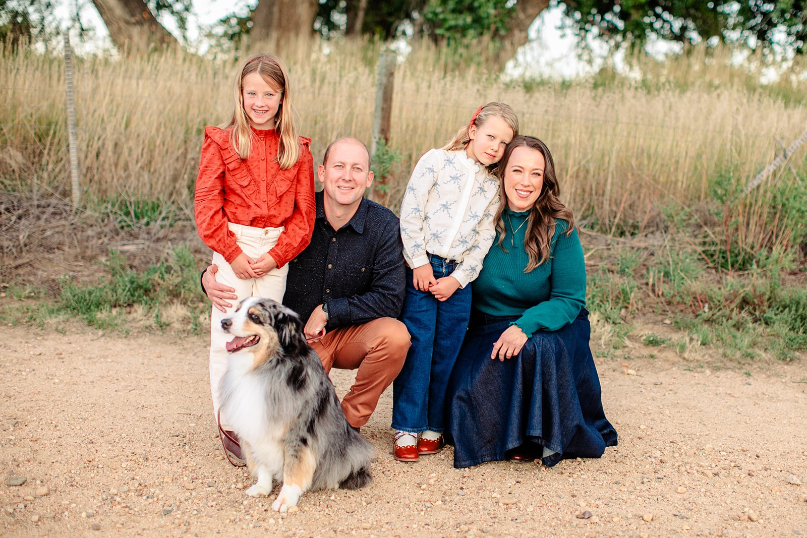 family with dog standing together during outdoor spring mini session near Boulder Colorado