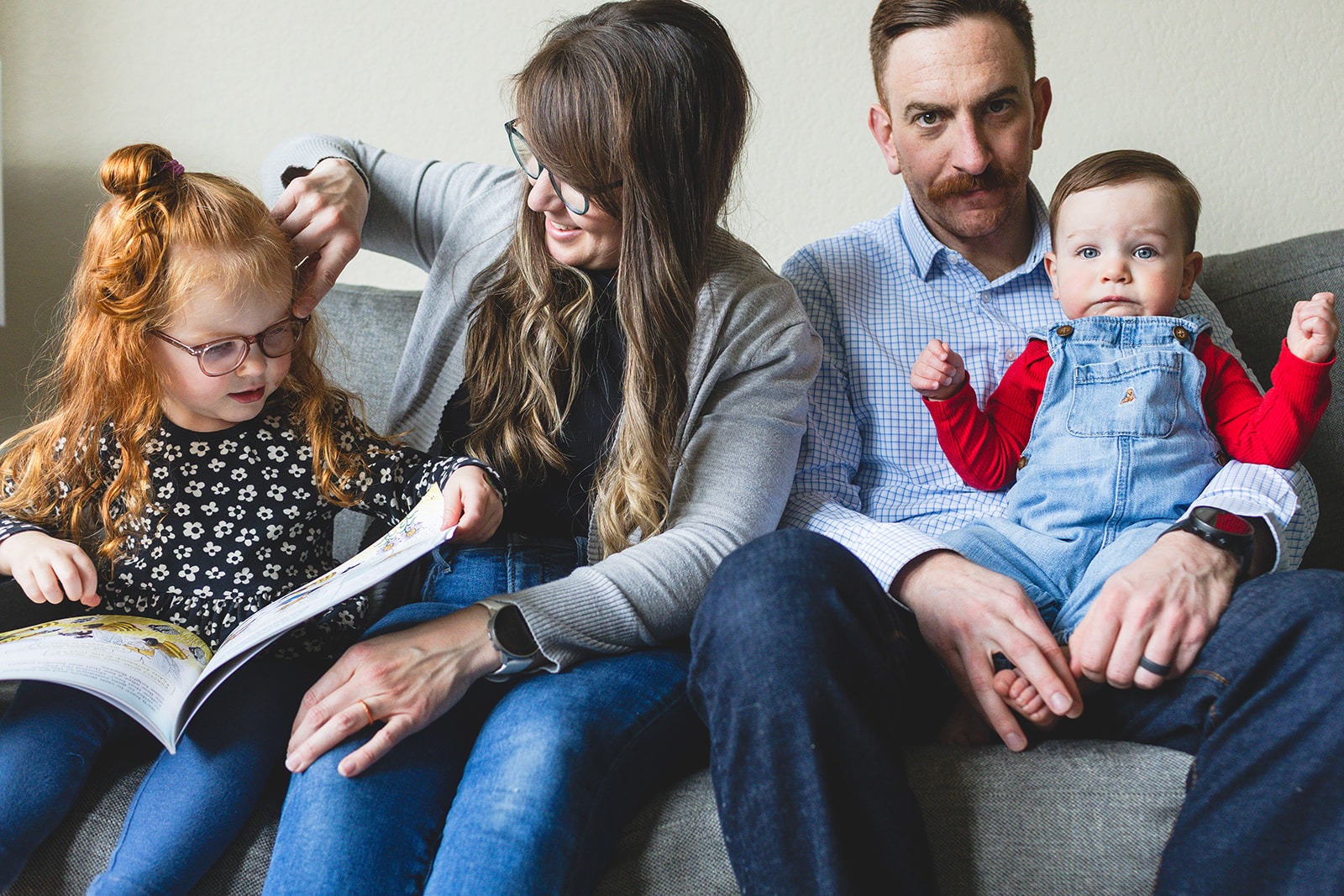 family sitting together casually on couch during in-home photo session