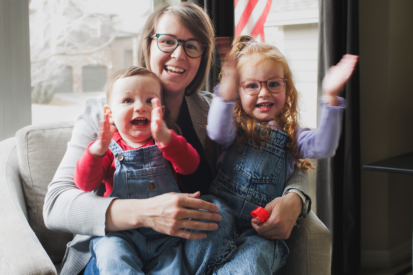 mother holding baby smiling during in-home photography session