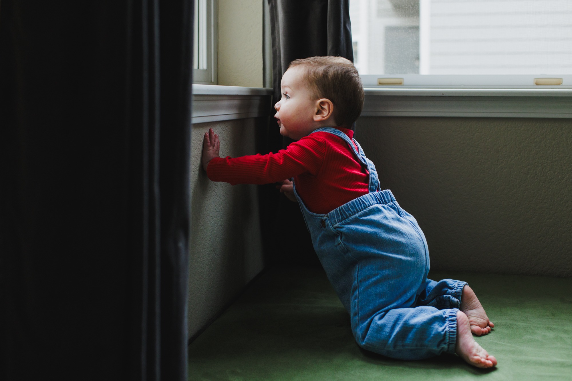 toddler standing by window during in-home family session