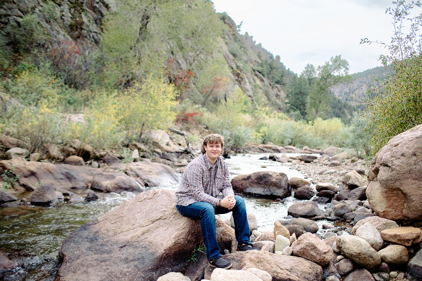 Holy Family High School senior poses by a river during his Lyons, Colorado senior session
