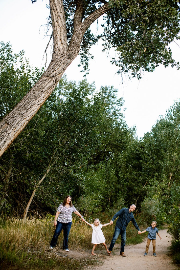 family holding hands under a tree in loveland colorado