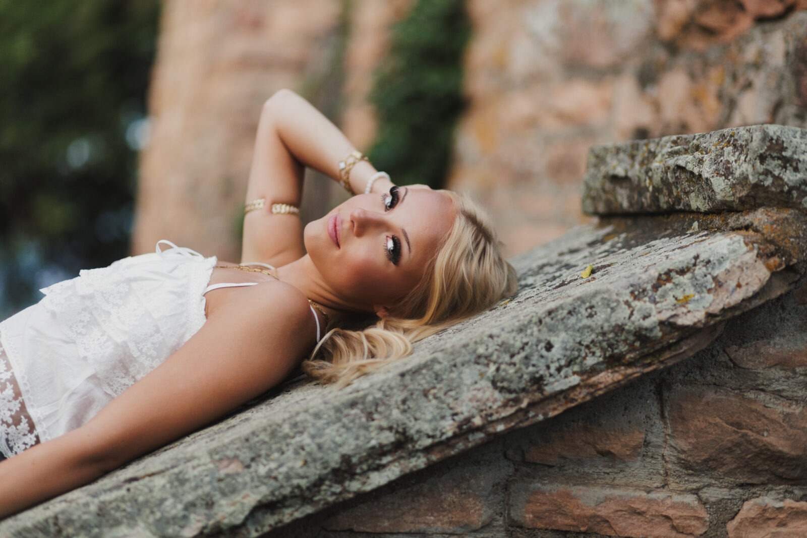 Boulder senior photography with senior lying on rock steps